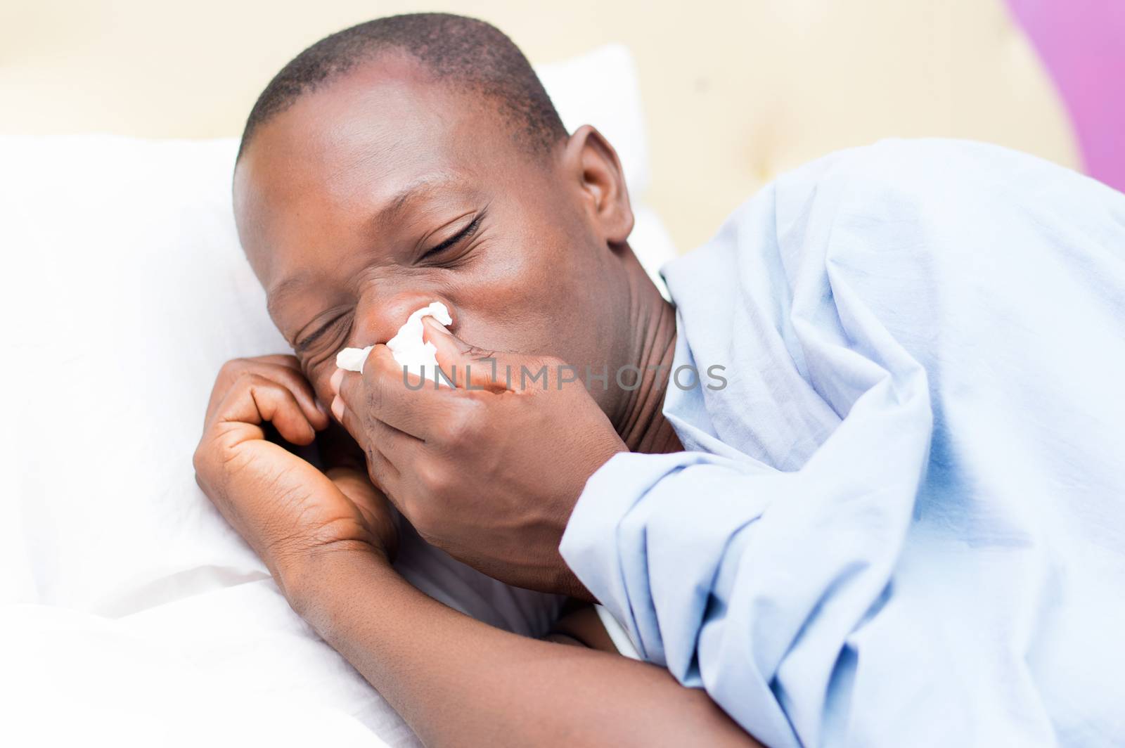 This young man lying on the bed is cold and feverish