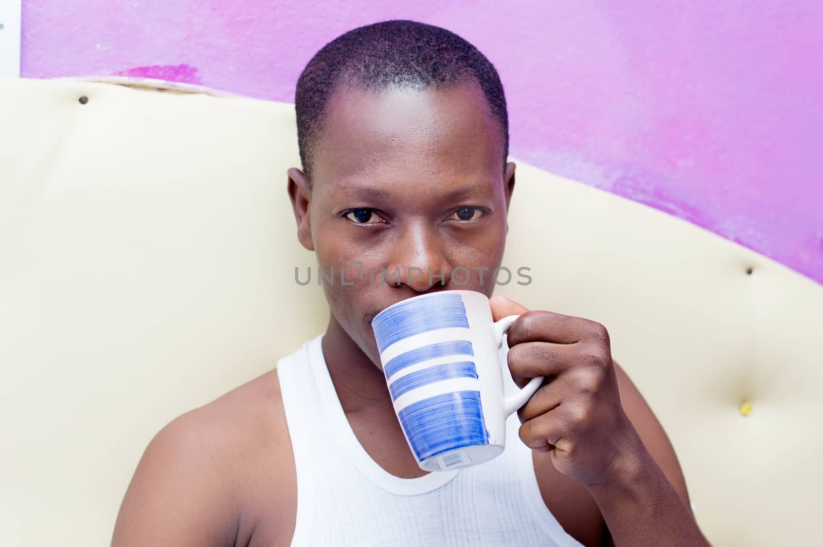 this young cheerful man drinks coffee in bed