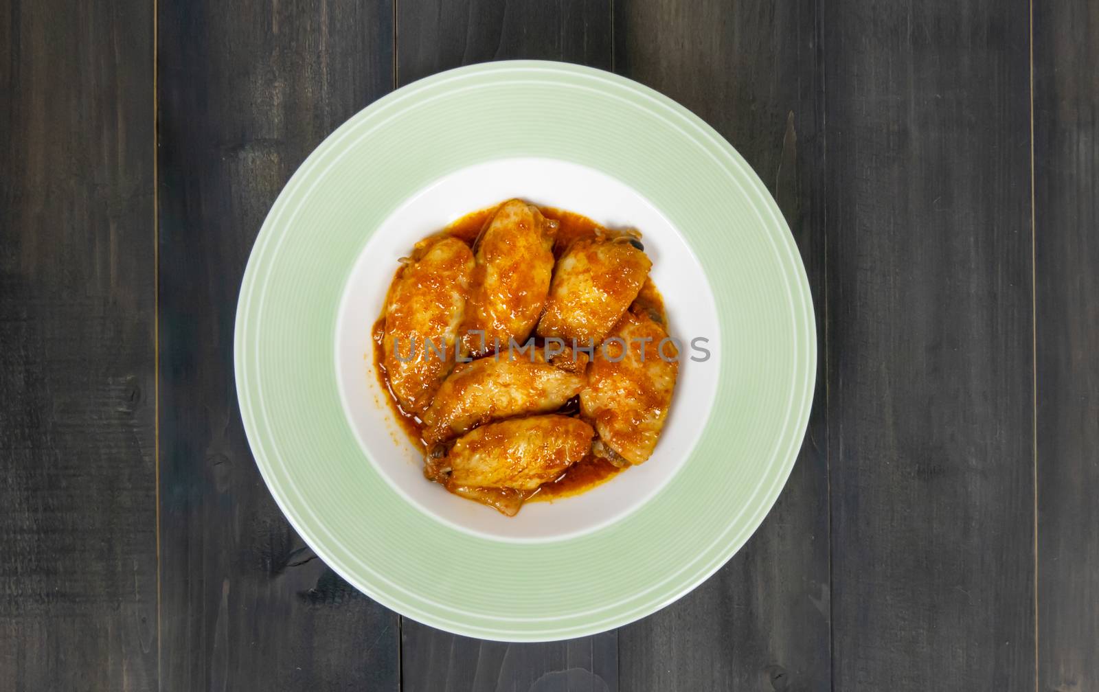 Baked chicken wings with spicy sauce. Food background with copy space. Top view