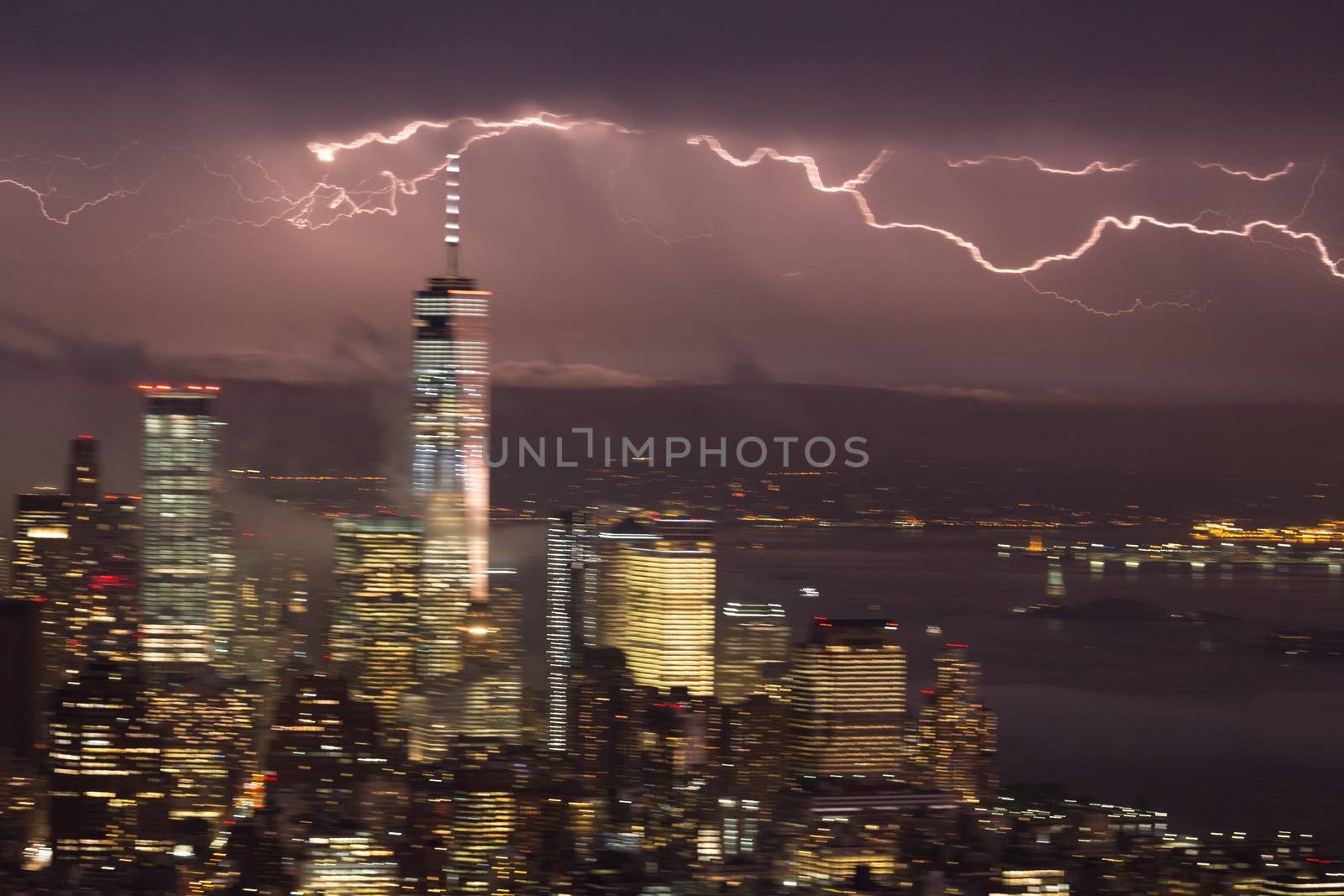 Artistic motion blured image of New York City skyline with lower Manhattan skyscrapers in lightning storm at night.