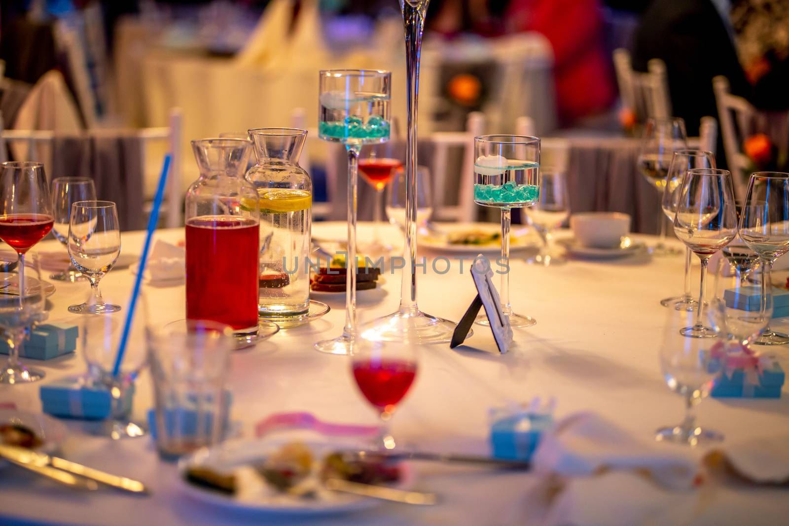 Jugs with lemonade and glasses on table at wedding party or banquet. Glasses and jugs with drinks setting on the festive table in restaurant.