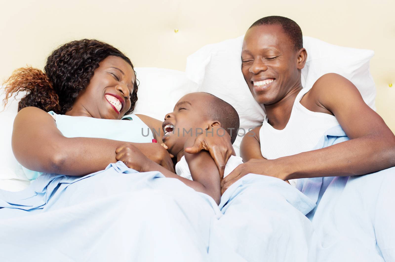 this family lying in bed is happy to share good holiday together