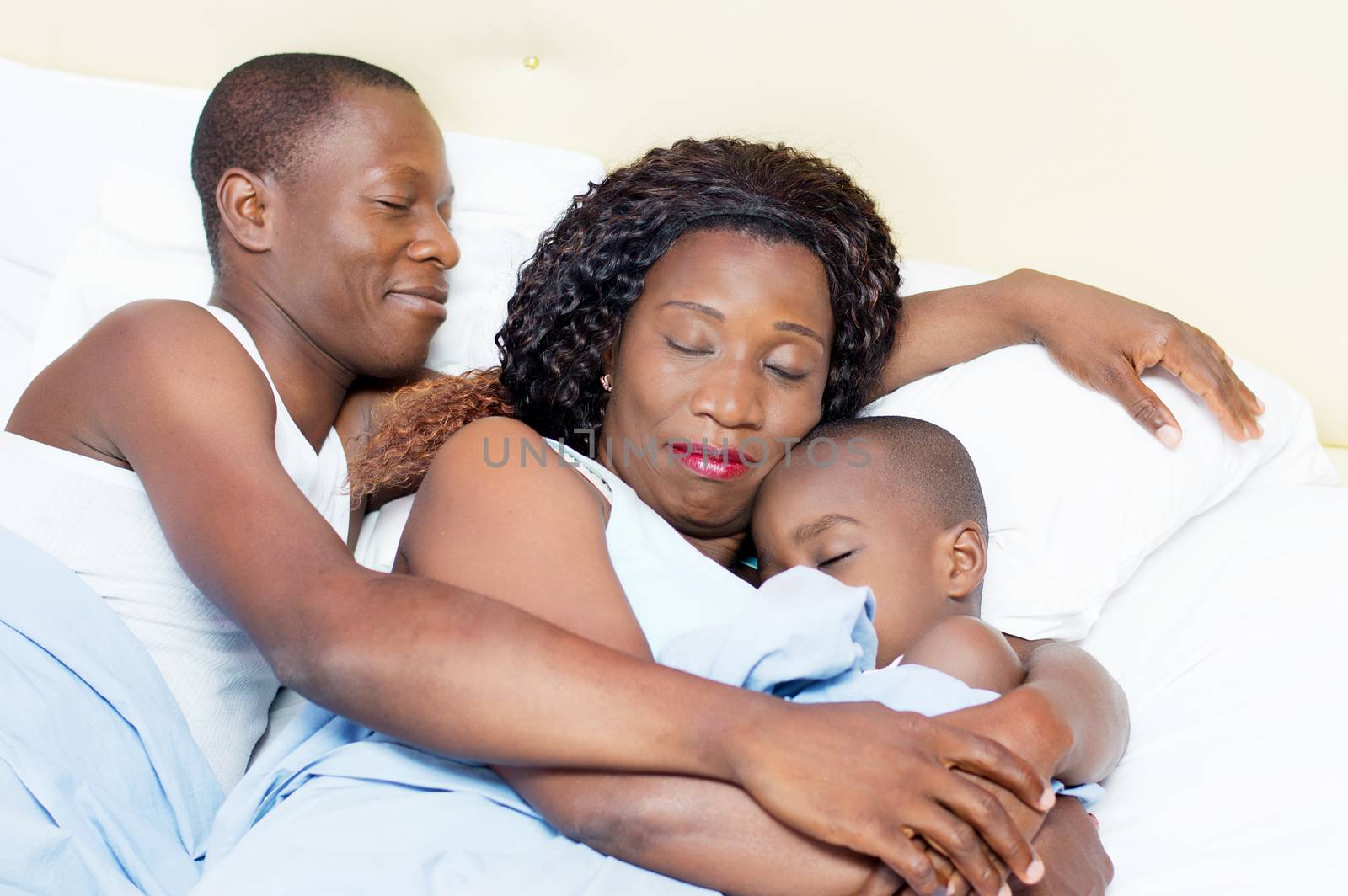 this family lying in bed sleeping peacefully