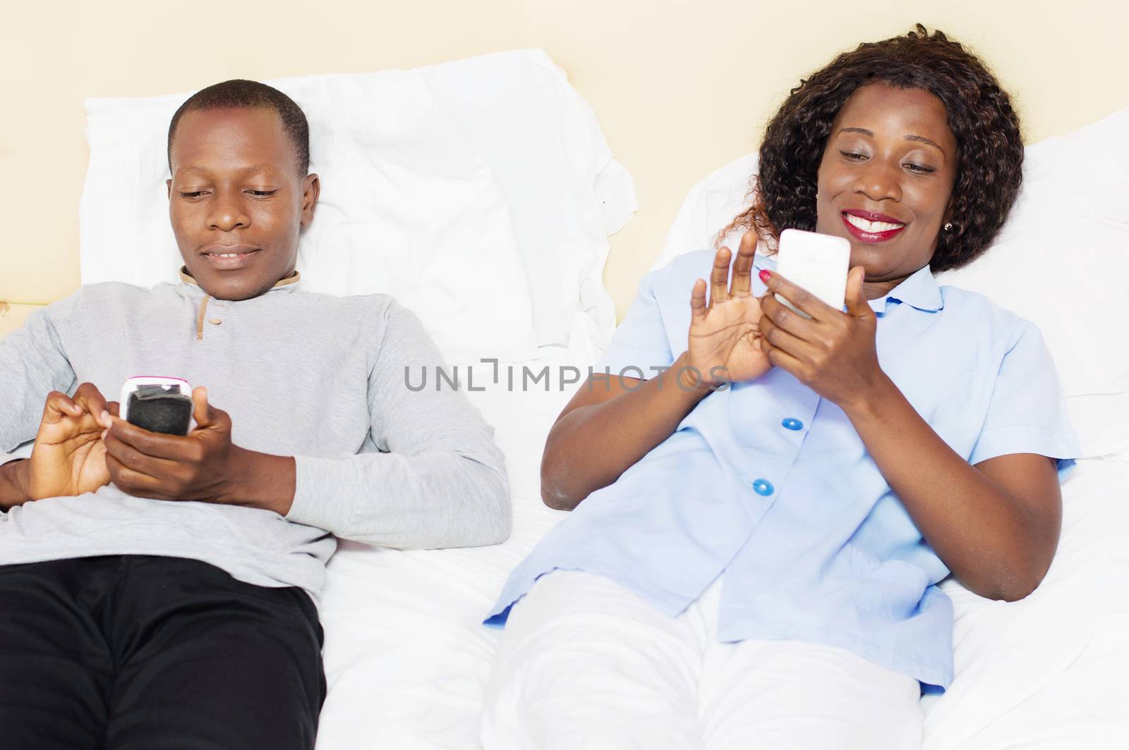 this young couple happy to handle each mobile phone in bed