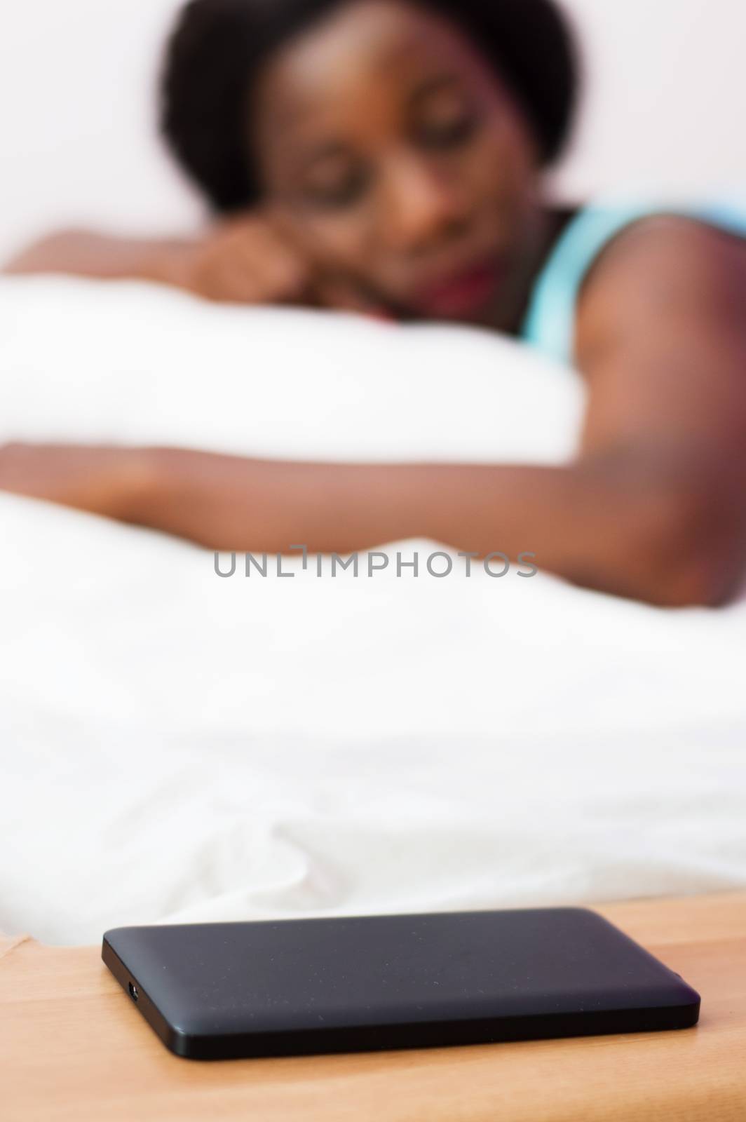 Her cell phone filed within reach of her hand, this young woman is sleeping deeply.