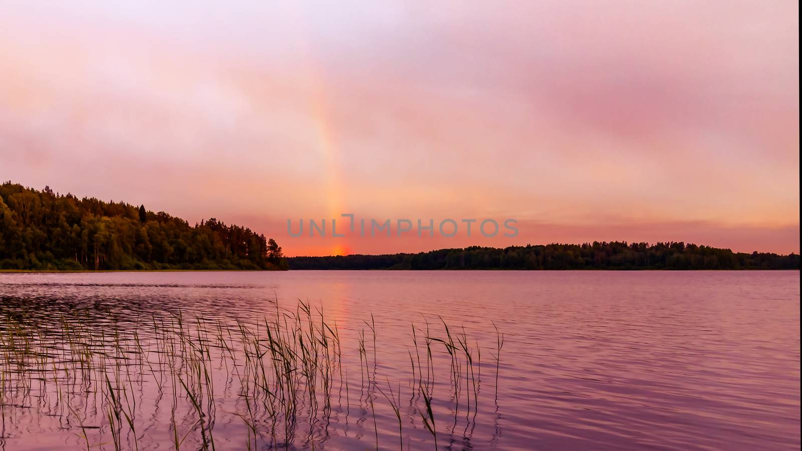 Rainbow over the lake at sunset by galsand