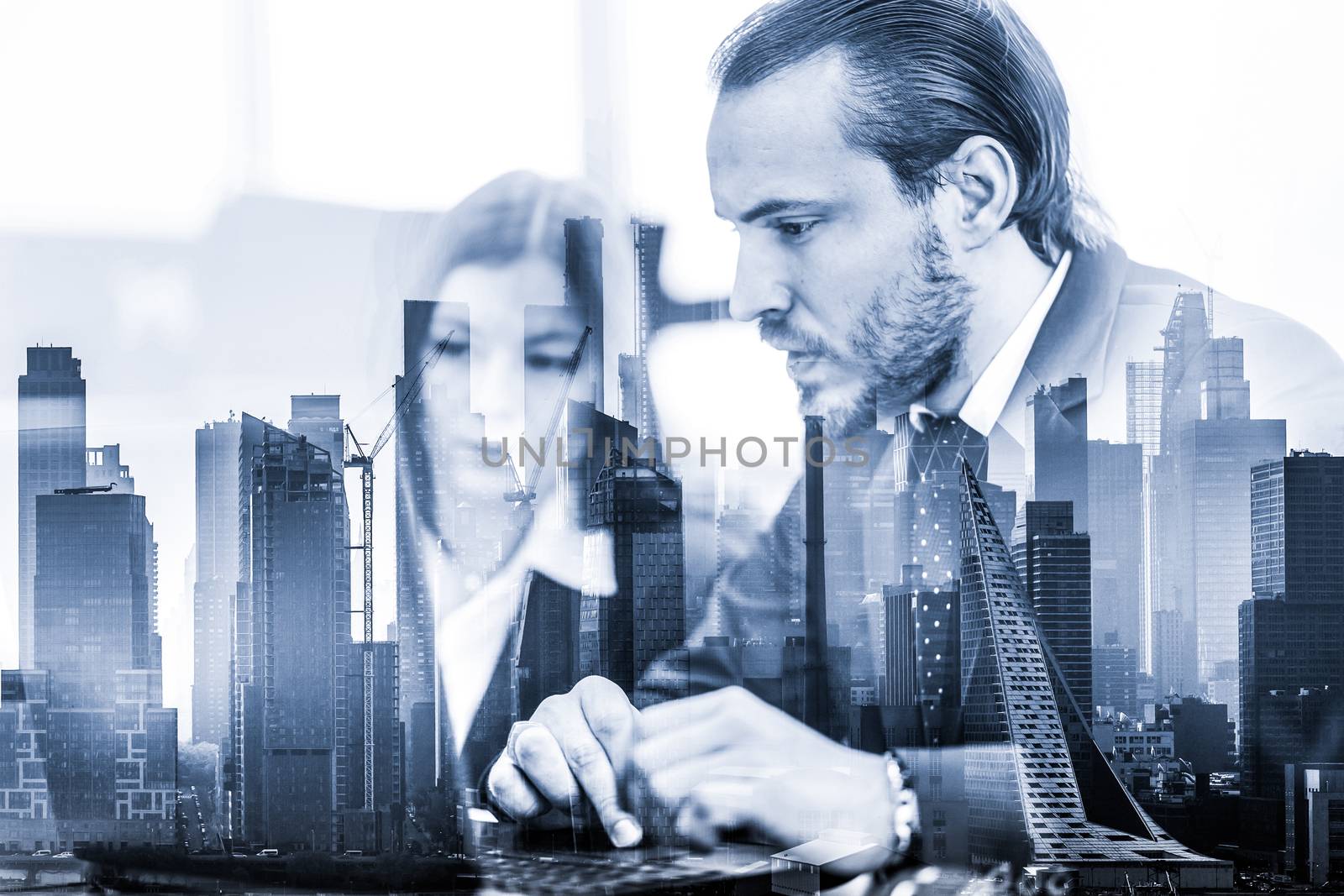 Business people working on laptops in modern office against new york city manhattan buildings and skyscrapers window reflections. Real estate investment and agency concept.