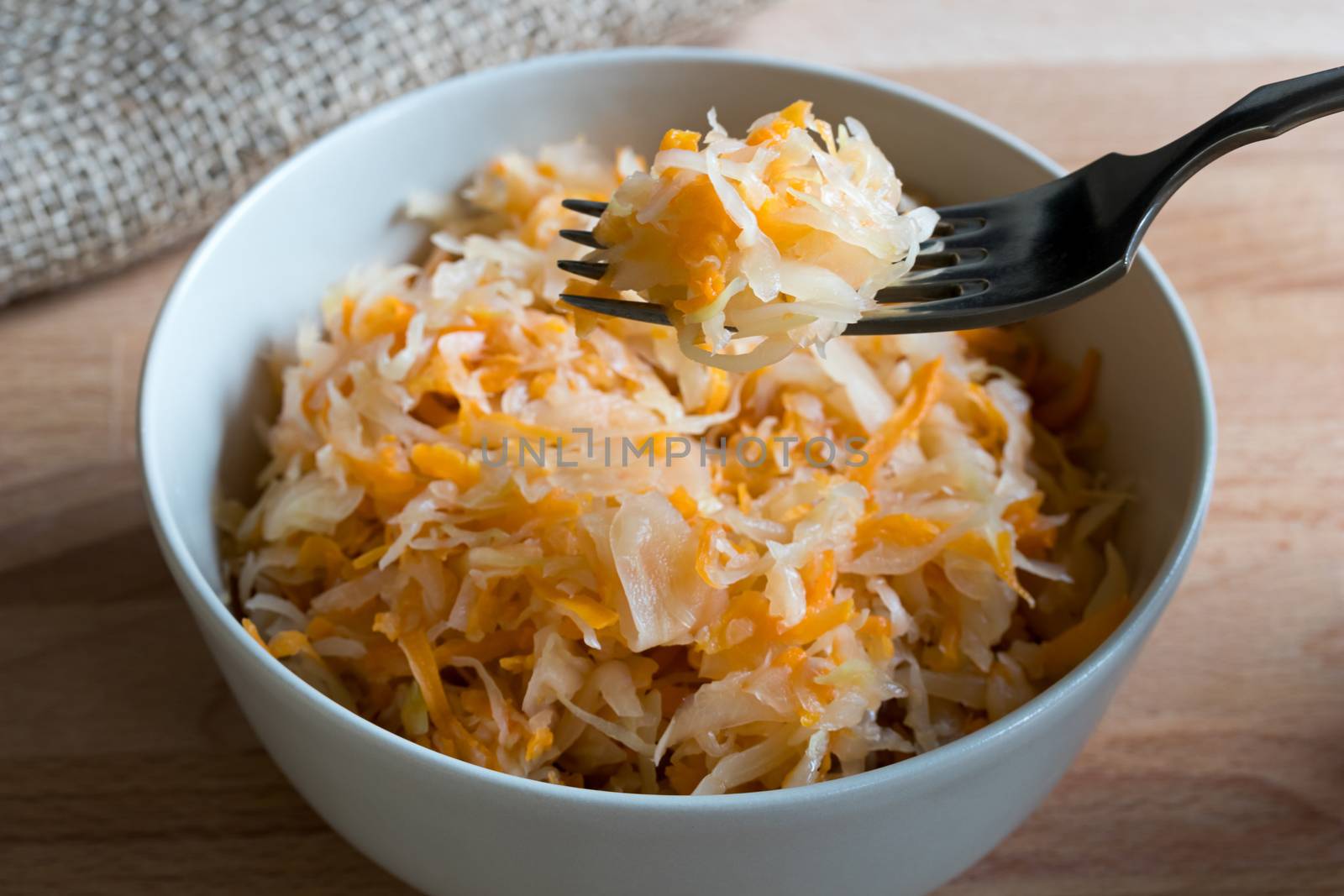 Fermented cabbage and carrots in a bowl and on a fork by madeleine_steinbach