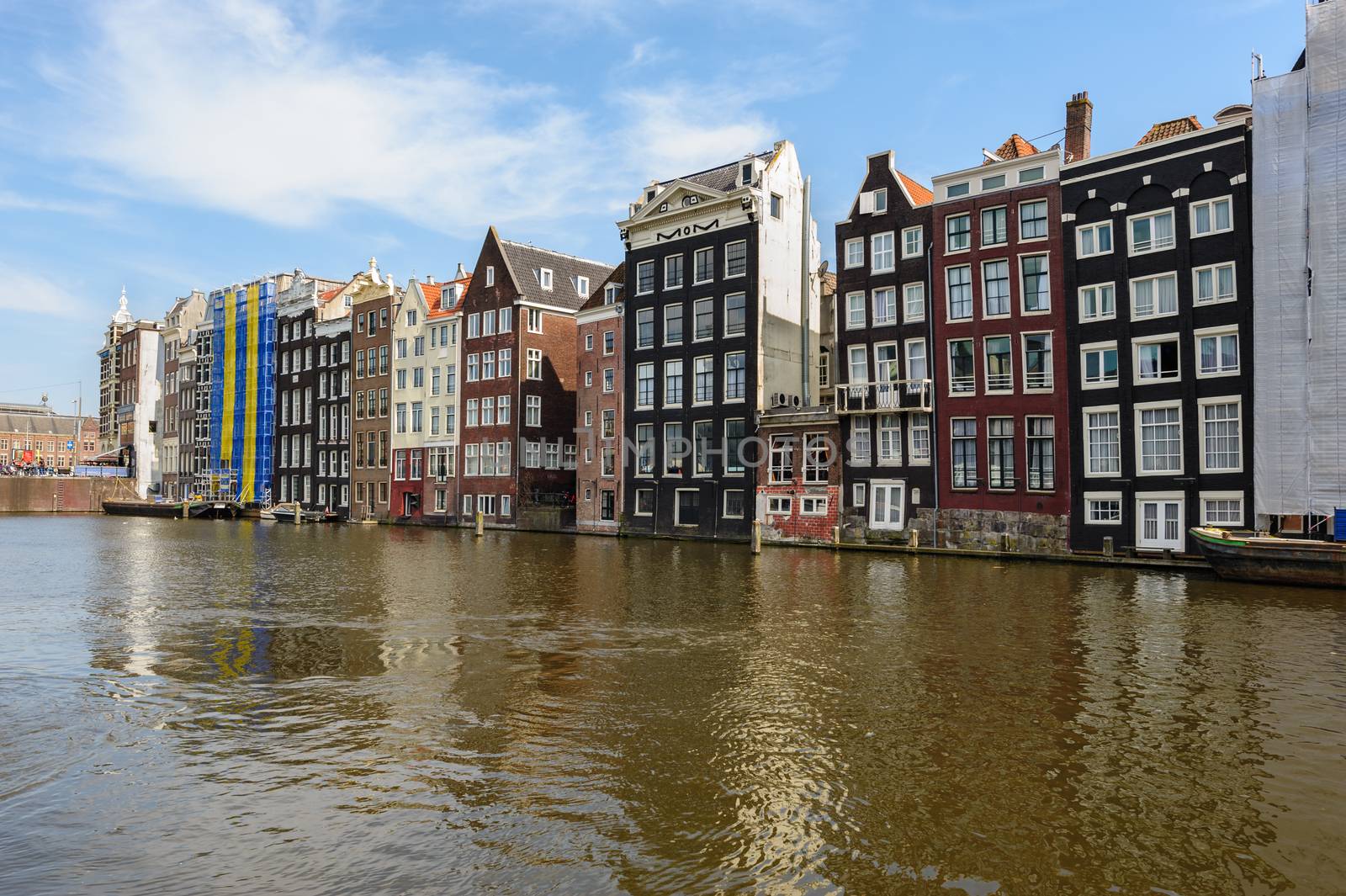 Spirngtime view of the Dancing Canal Houses of Damrak, iconic canal houses in the capital city of Amsterdam, Netherlands