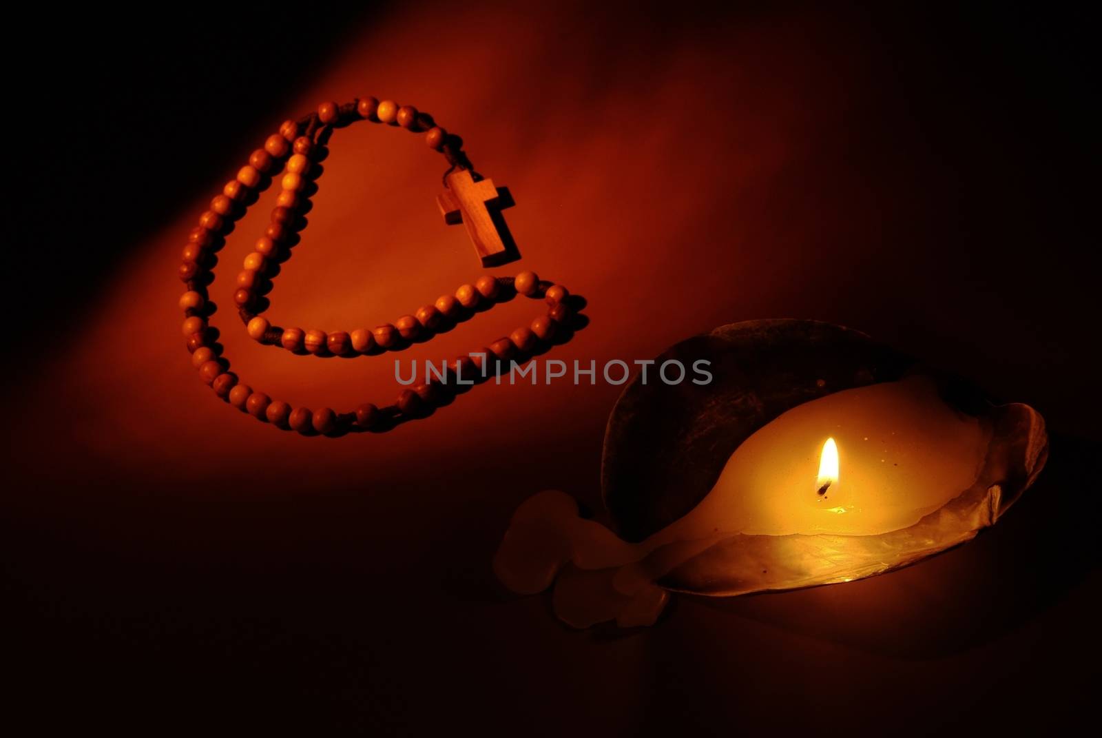 Prayer and hope concept. Retro candle light and red flower. by romeocharly