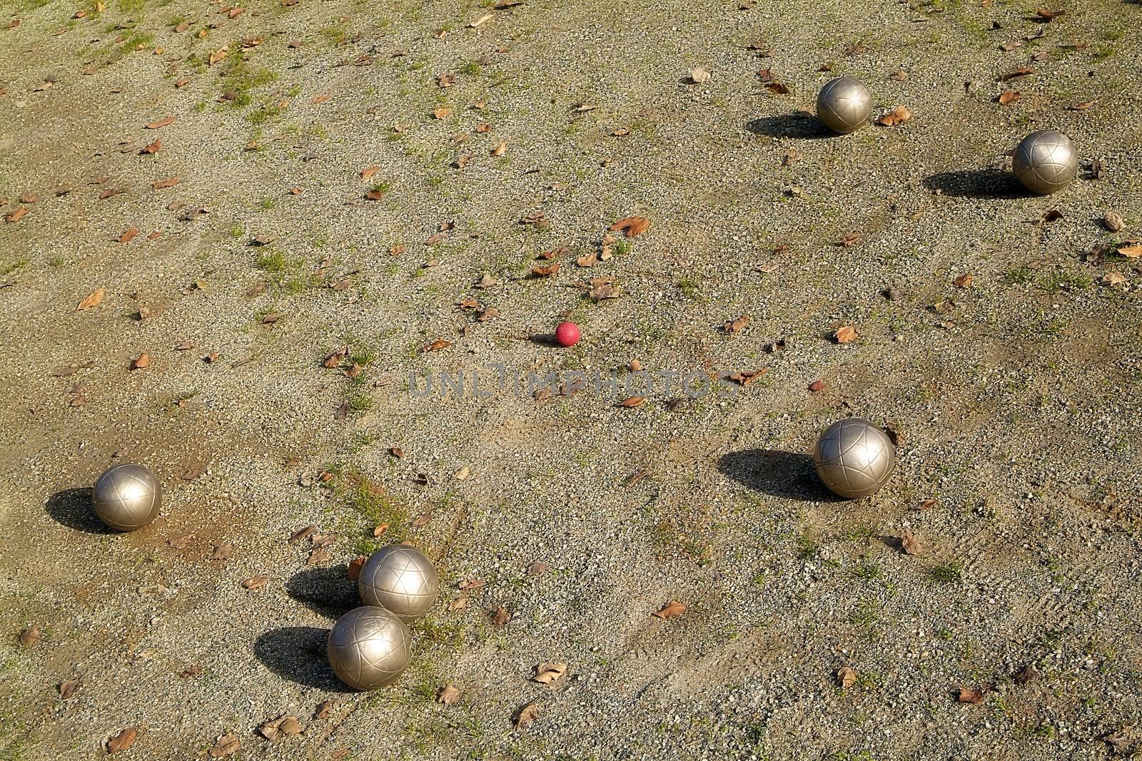 Four Boccie balls on the dike of in italy in front of blue North sky