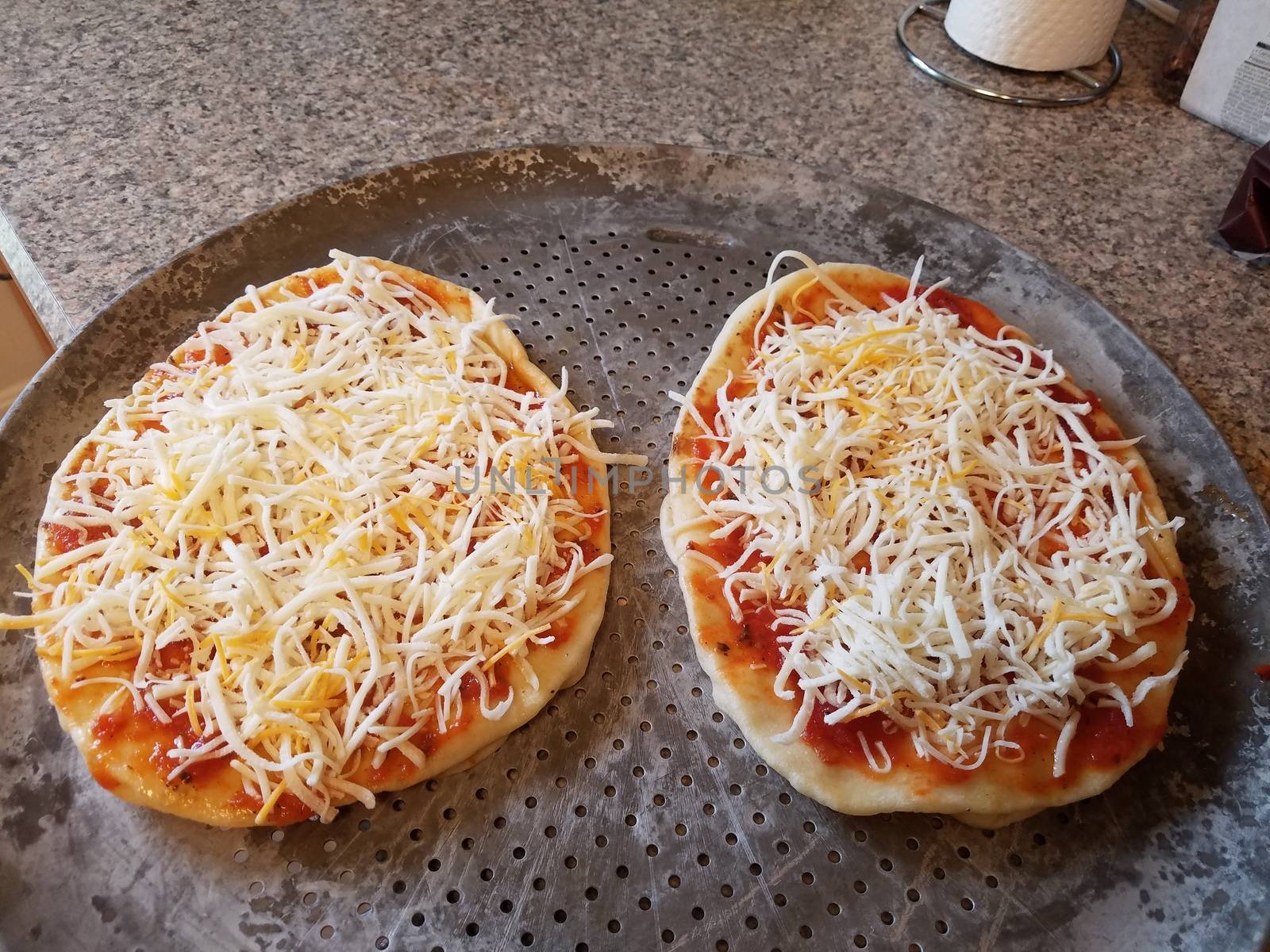 two personal size or mini pizzas on baking tray by stockphotofan1