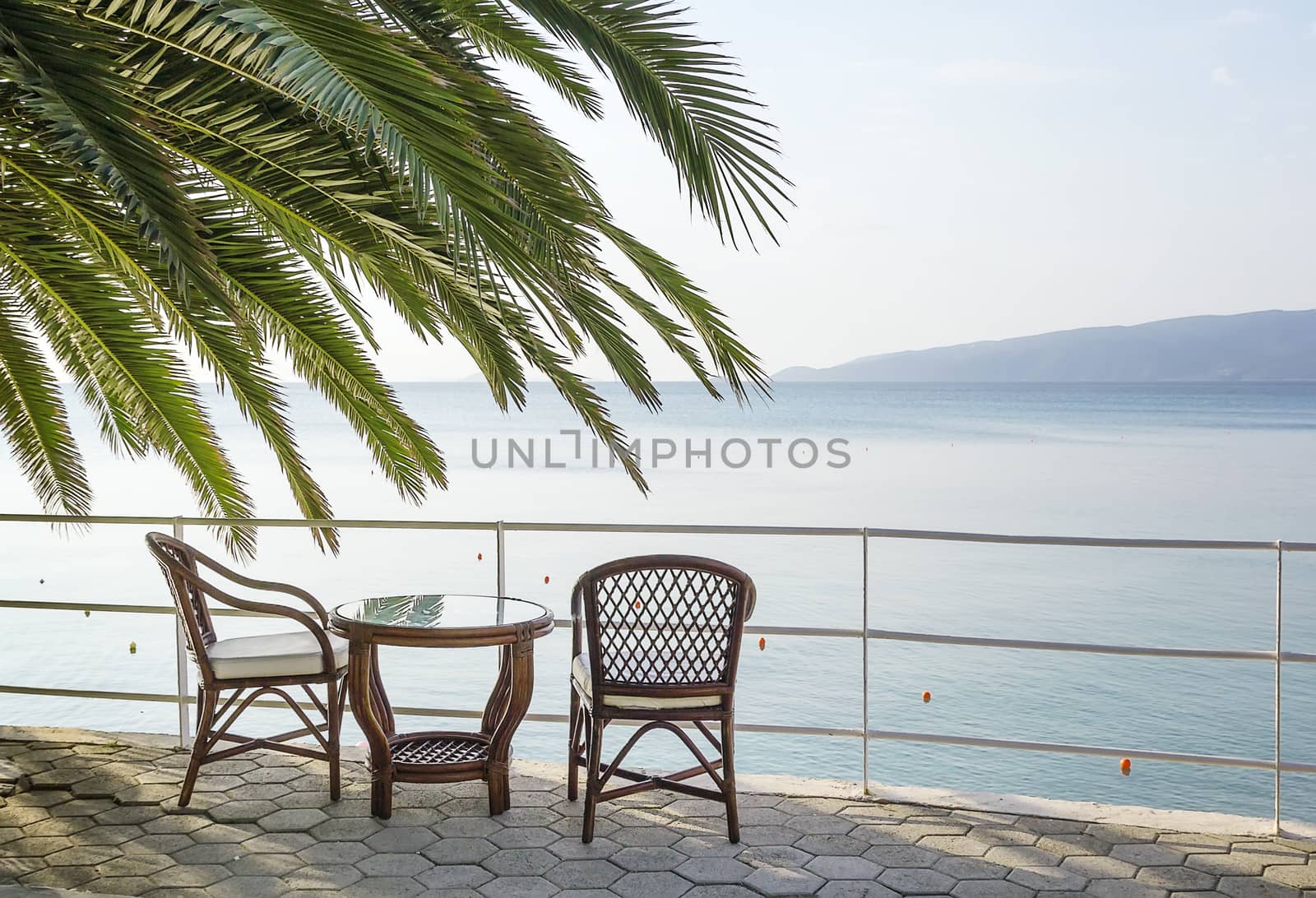 table and chairs overlooking the sea by borisb17