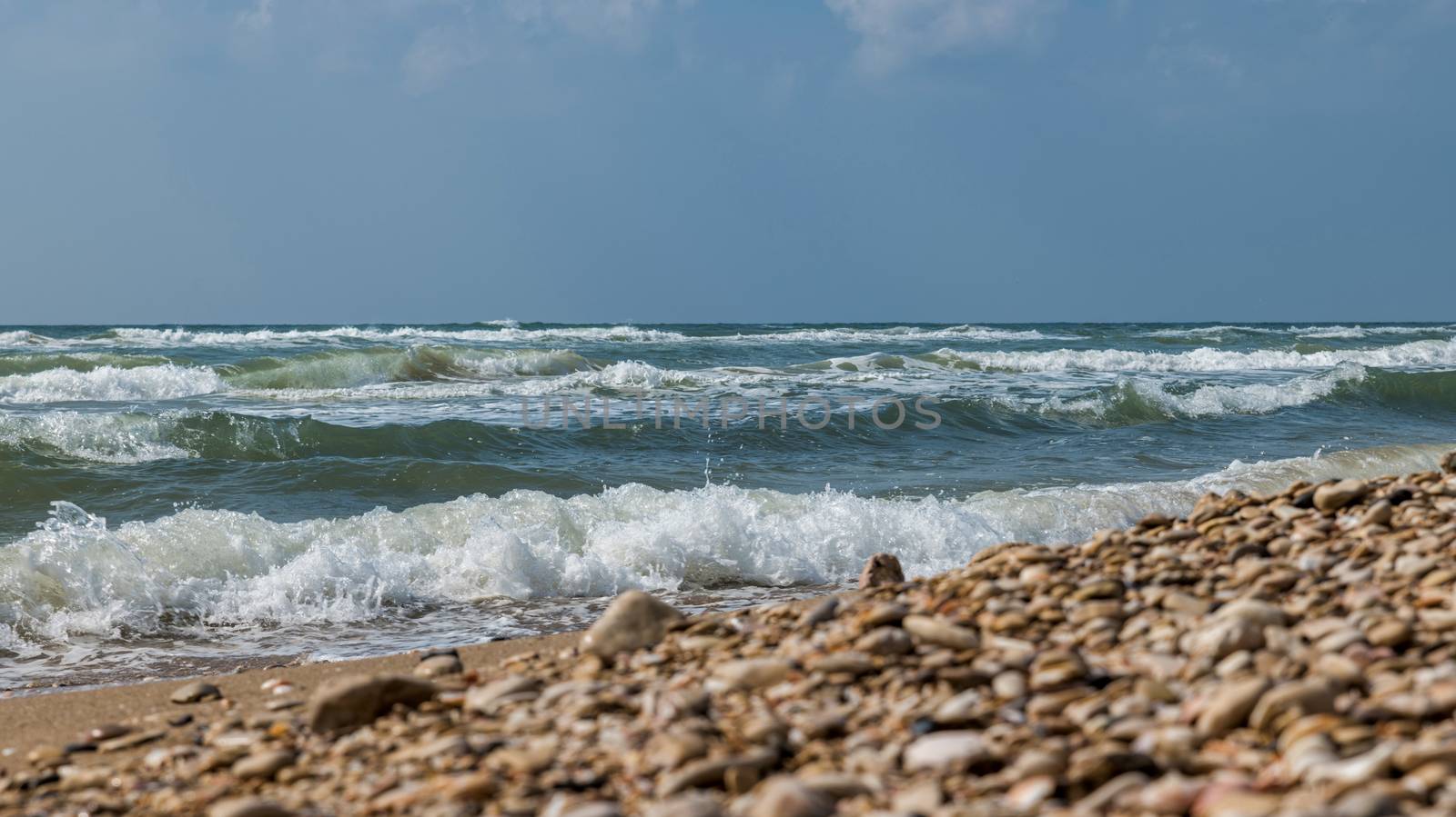 the ocean near tel aviv in israel with waves and rocks on the beach