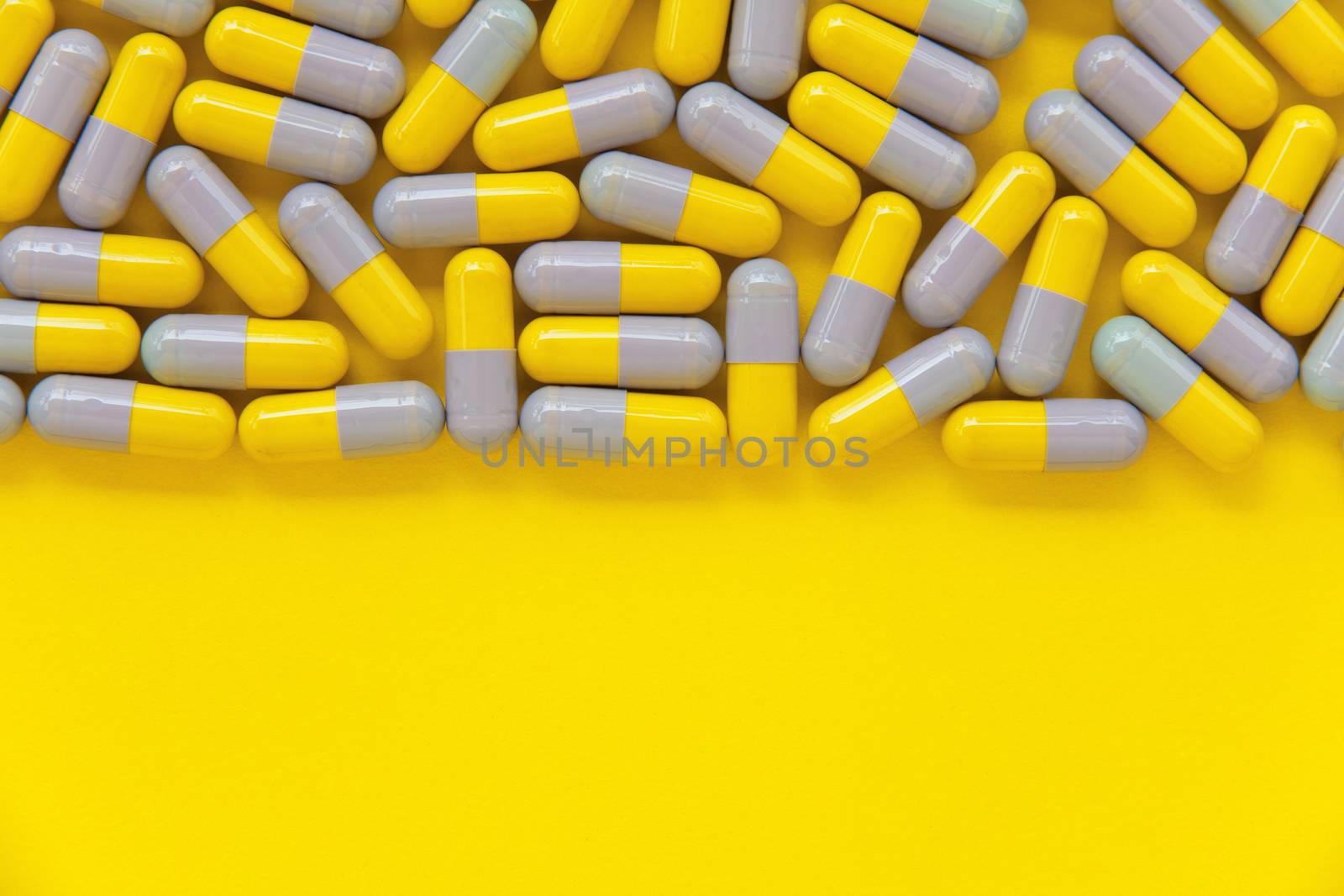 Capsule pills on yellow background