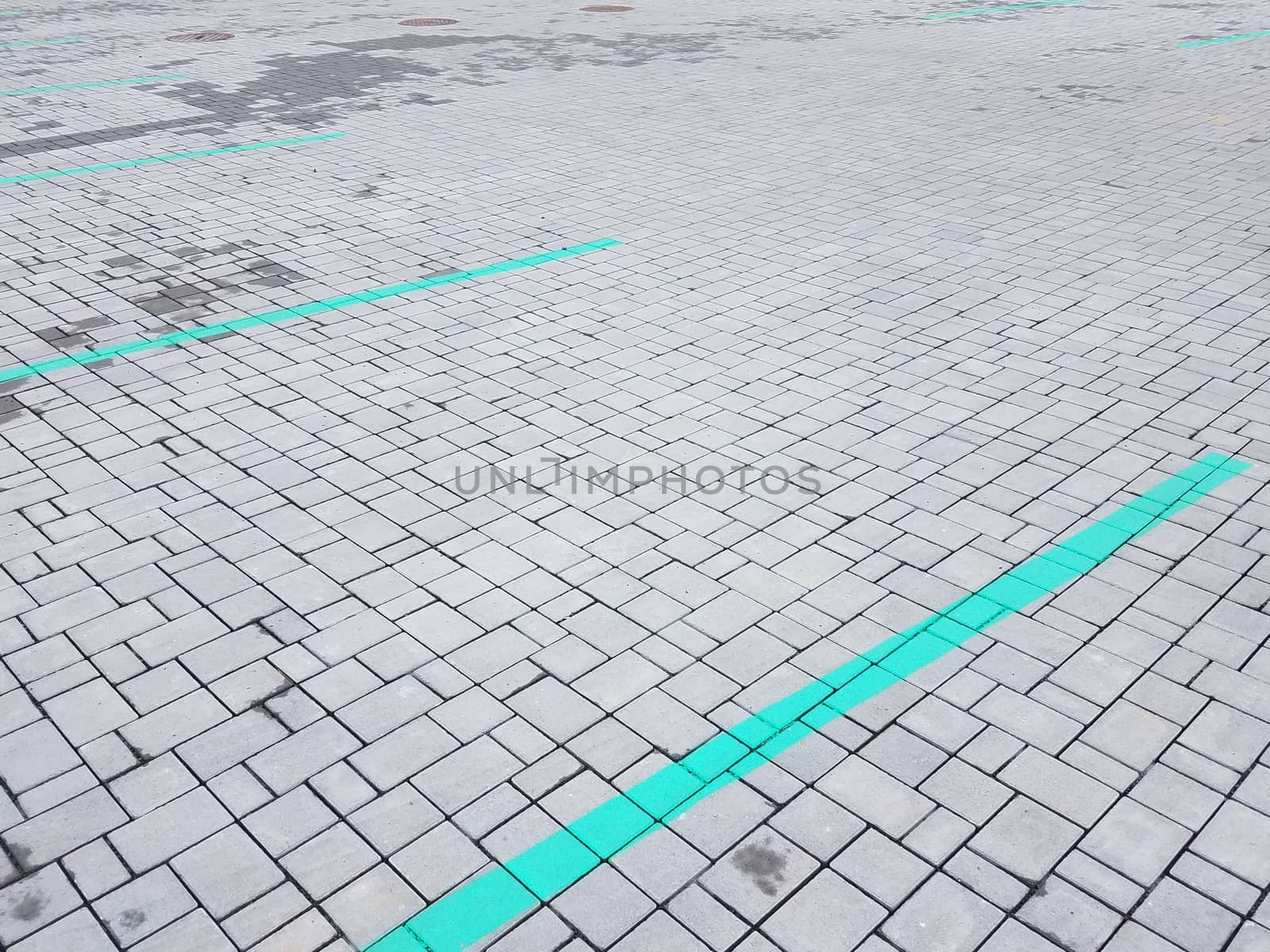 grey stone tiles rectangle and square shapes or background with green lines in parking lot