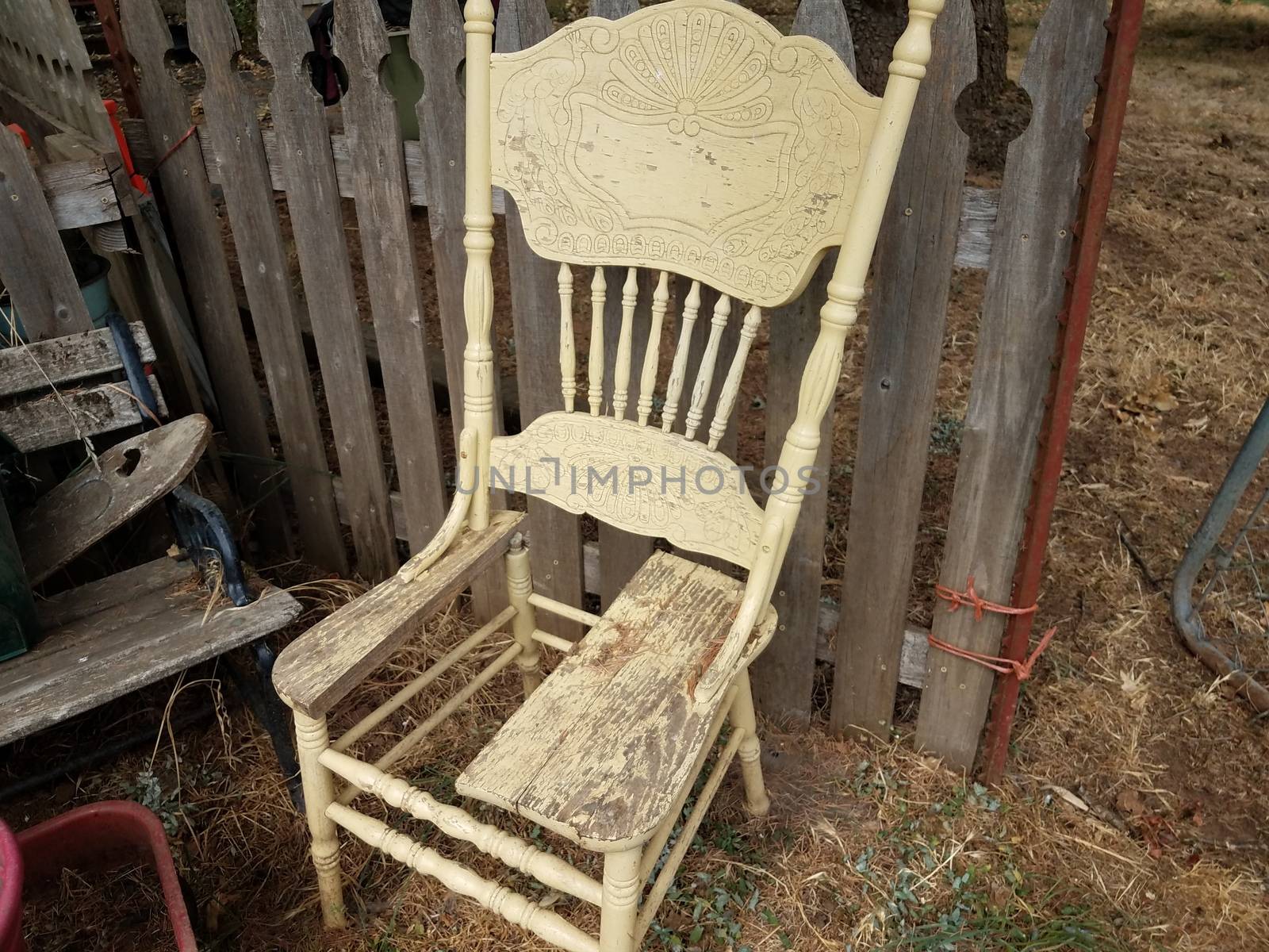 old broken wood chair with no seat bottom near fence by stockphotofan1