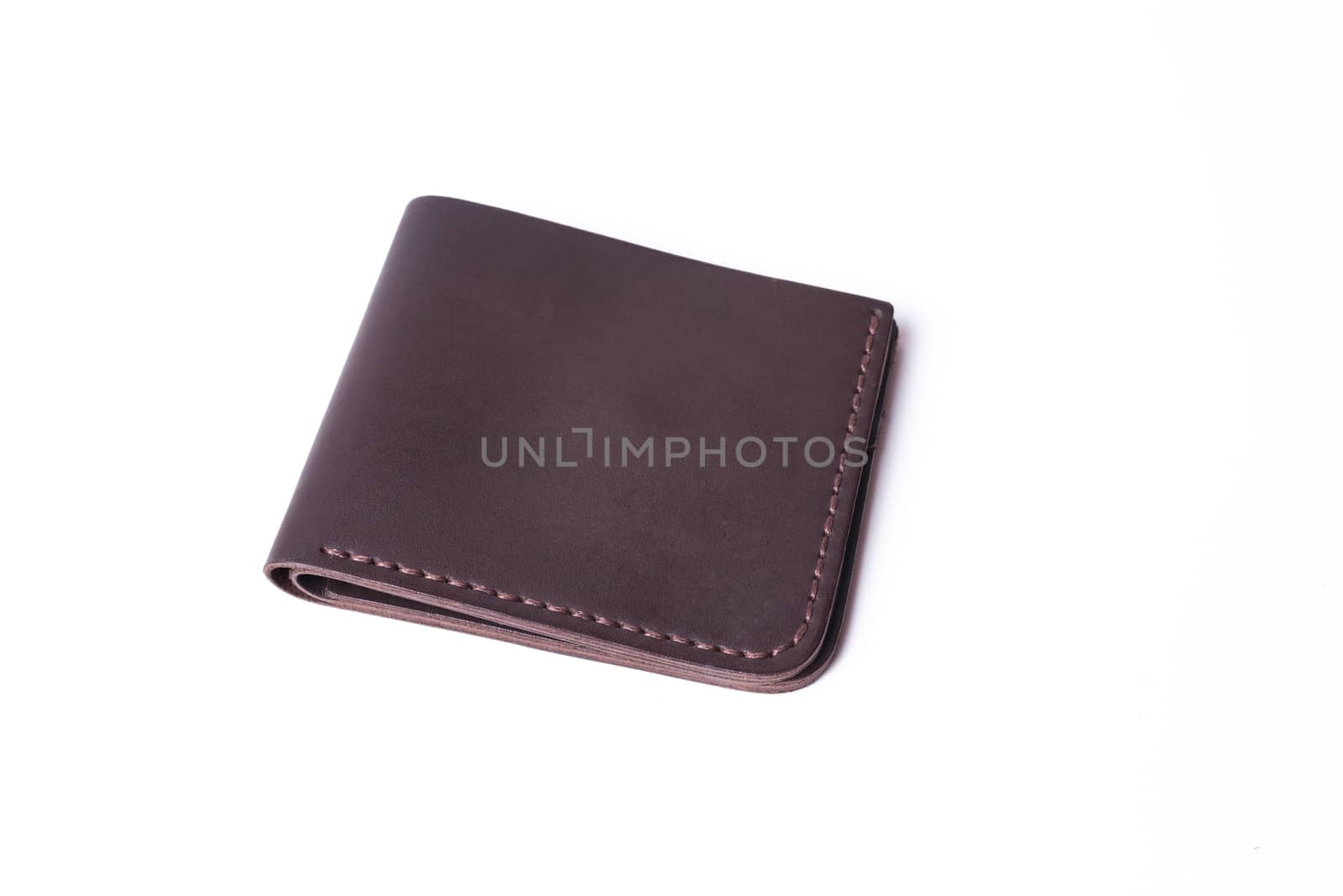 Brown handmade leather wallet isolated on white background. Wallet is closed. Stock photo of luxury businessman accessories.