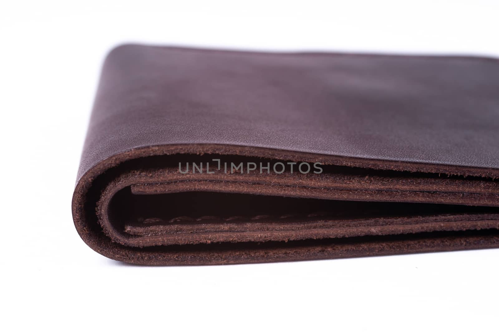 Brown handmade leather man wallet isolated on white background. Wallet is closed. Stock photo of luxury businessman accessories. by alexsdriver