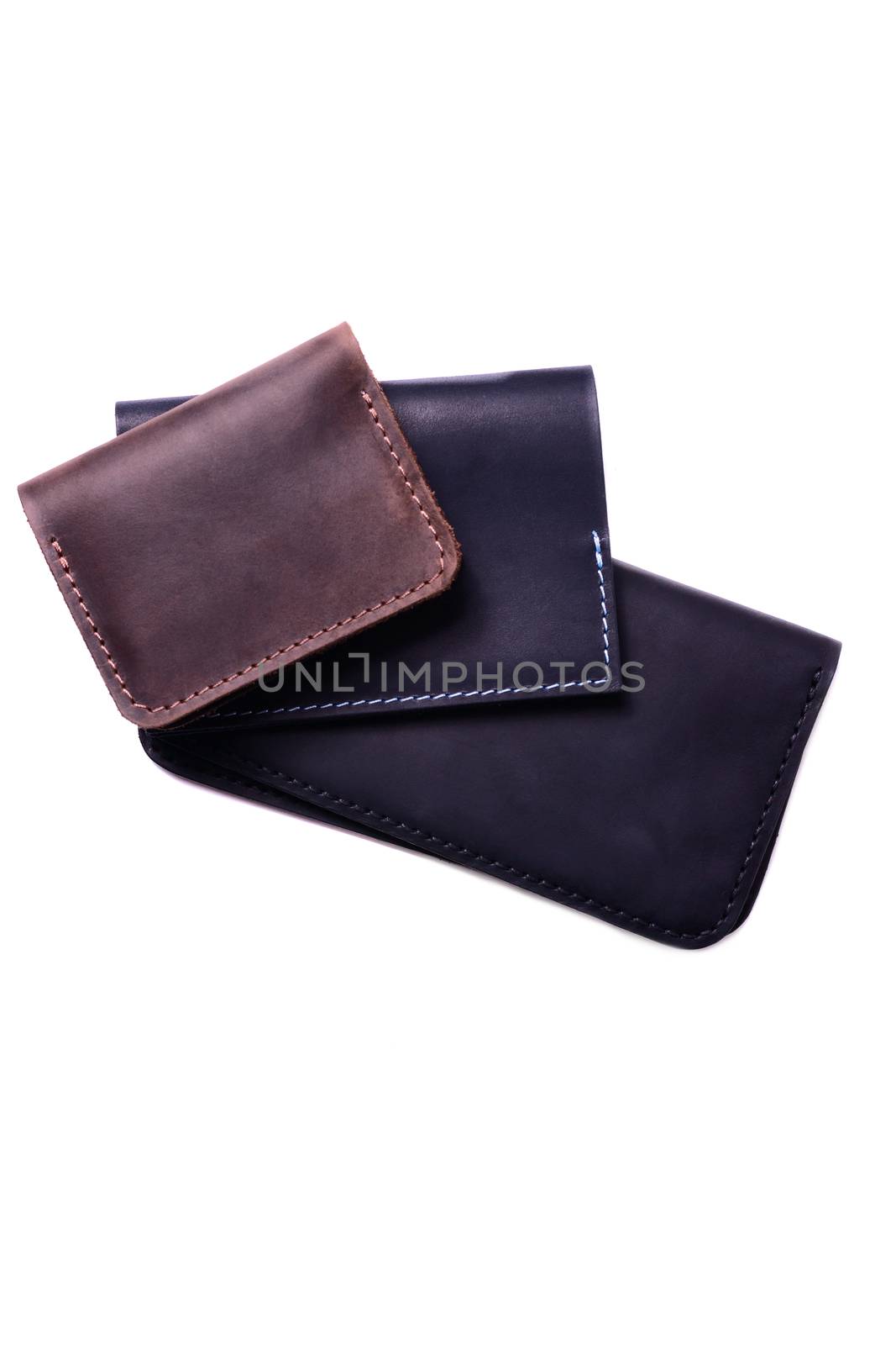 Handmade brown cardholder, black passport cover and purse isolated on white background closeup. Stock photo of handmade luxury accessories.