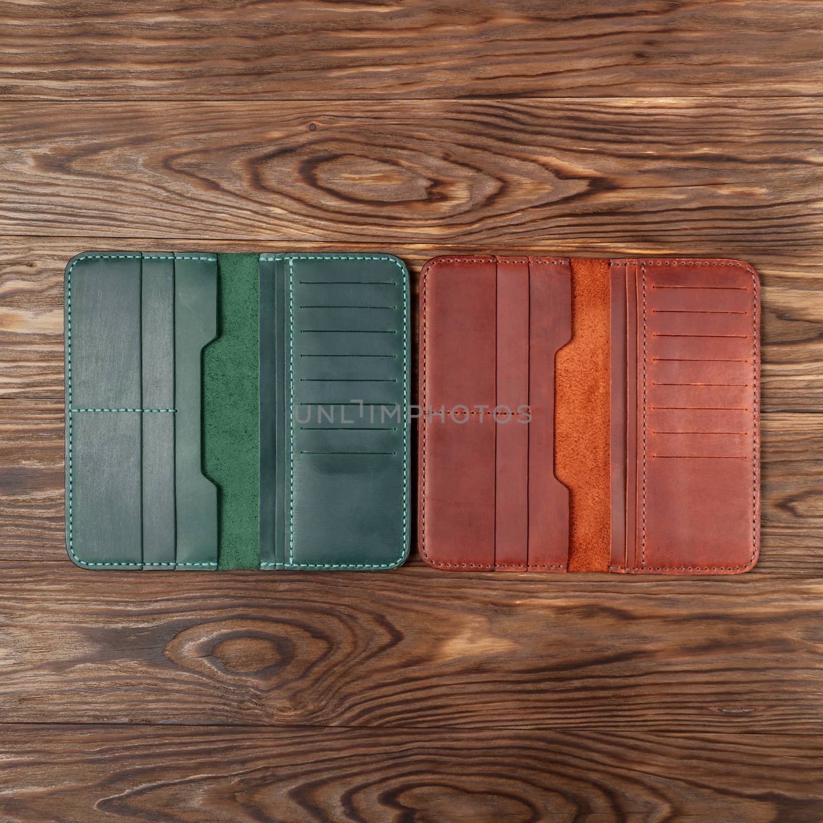 Two  handmade leather  opened porte-monnaie on wooden textured background. Up to down view. Stock photo of luxury accessories.