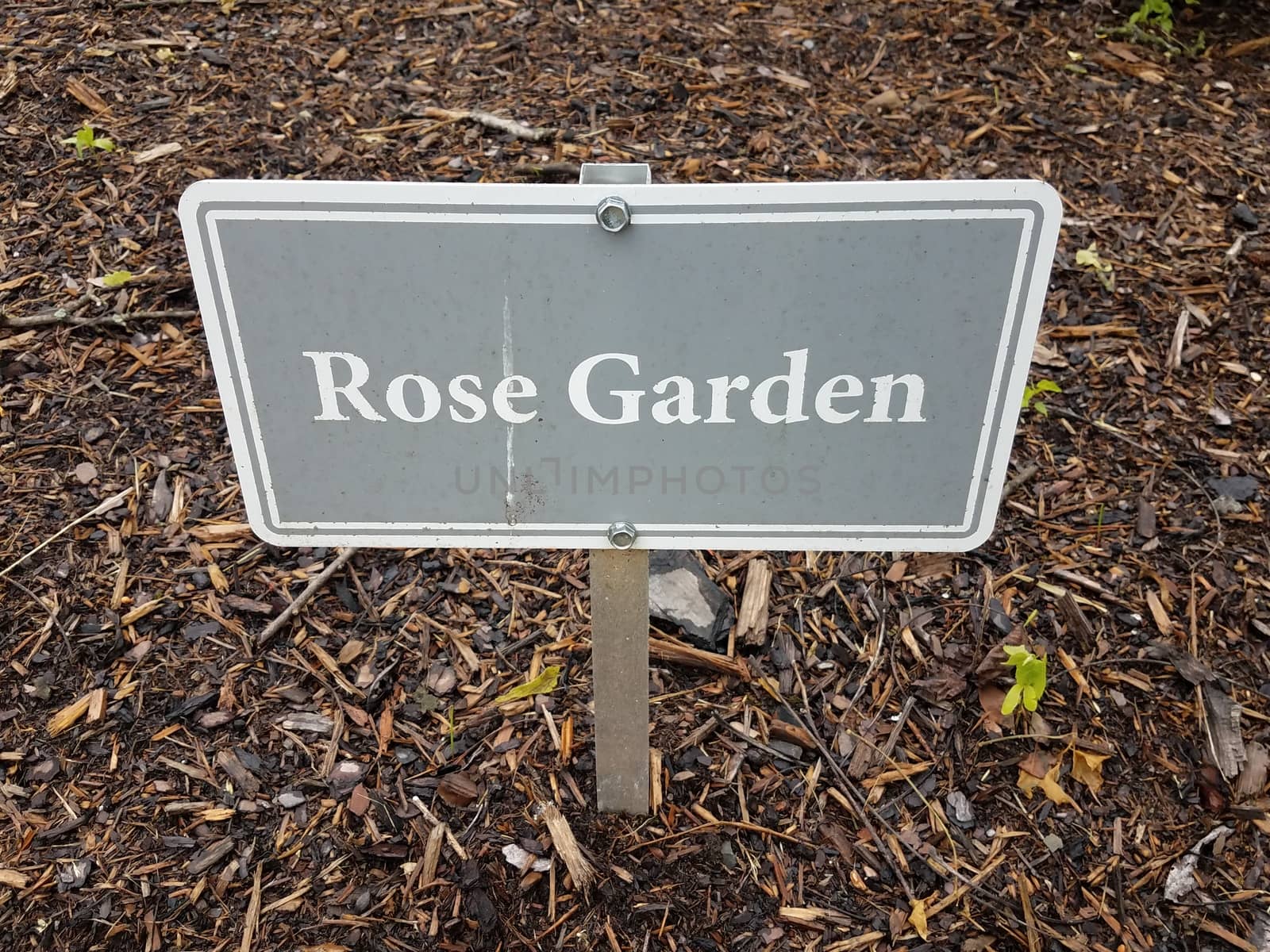 grey rose garden sign and brown mulch or wood chips by stockphotofan1