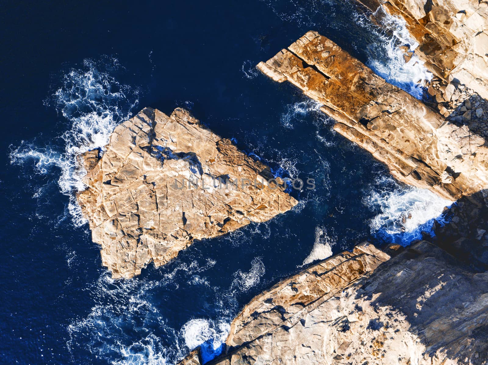 Slabs of exposed rock in deep ocean water off the coast of Australia