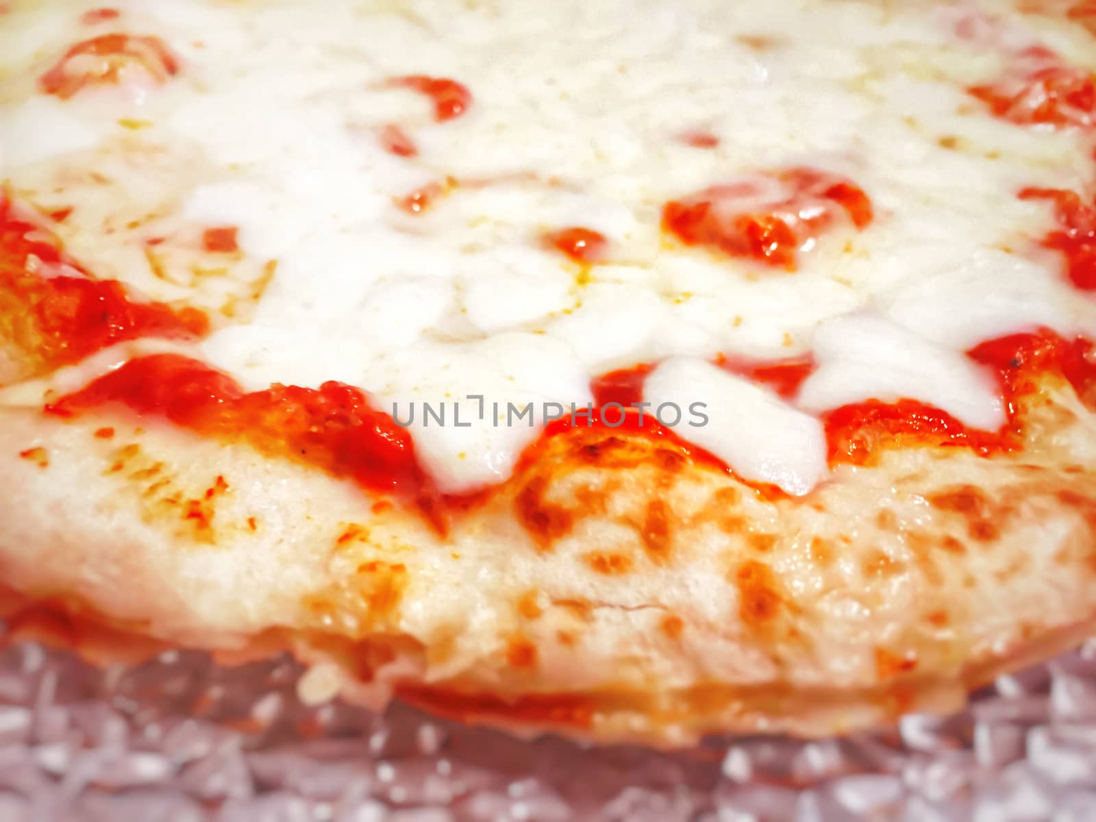 detail of a margherita pizza topped with tomato sauce and mozzarella cheese with crispy crust. Traditional Italian recipe. Typical Neapolitan cuisine