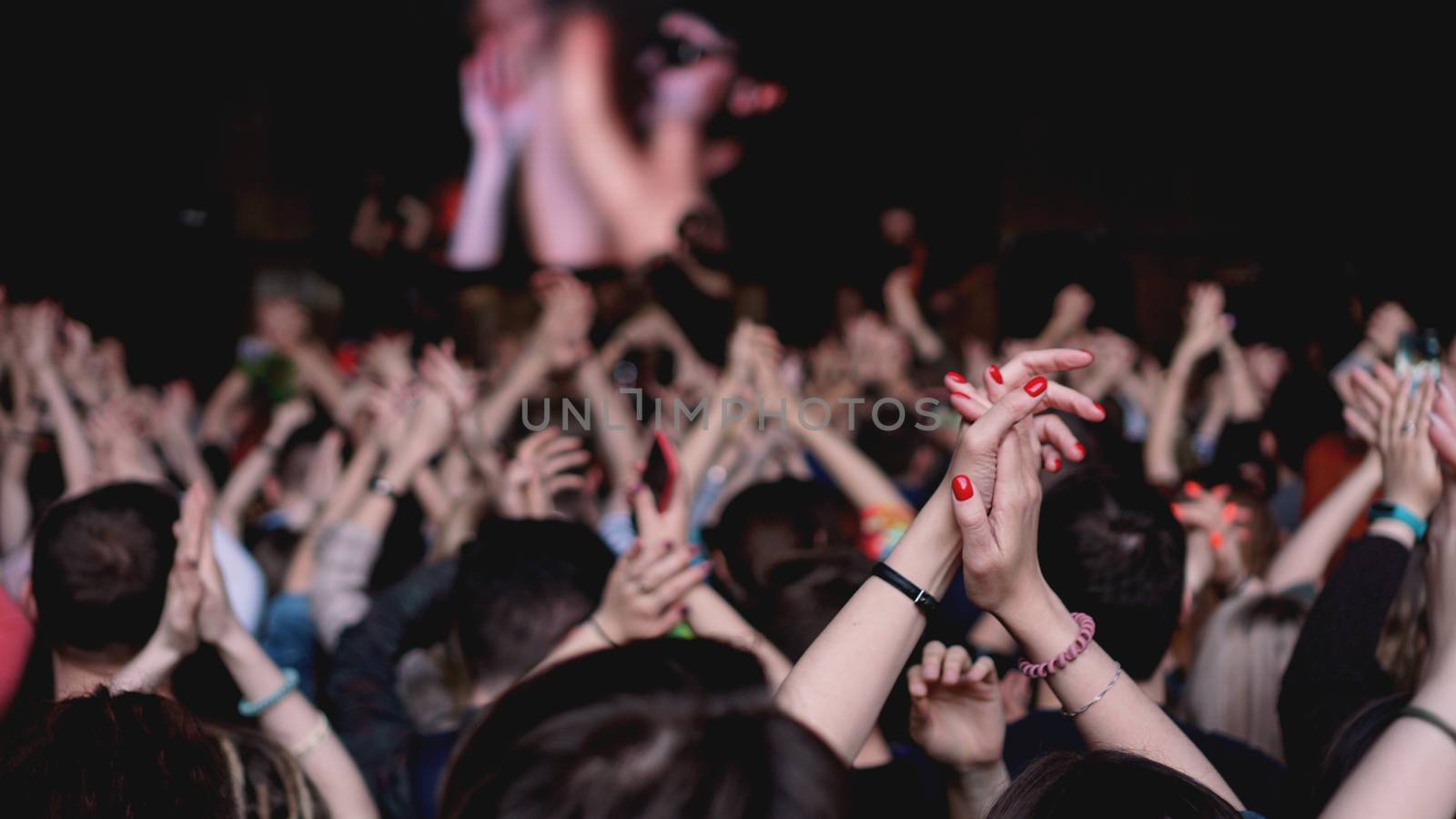 Crowd at concert - Cheering crowd in bright colorful stage lights. Audience At Outdoor Music Festival