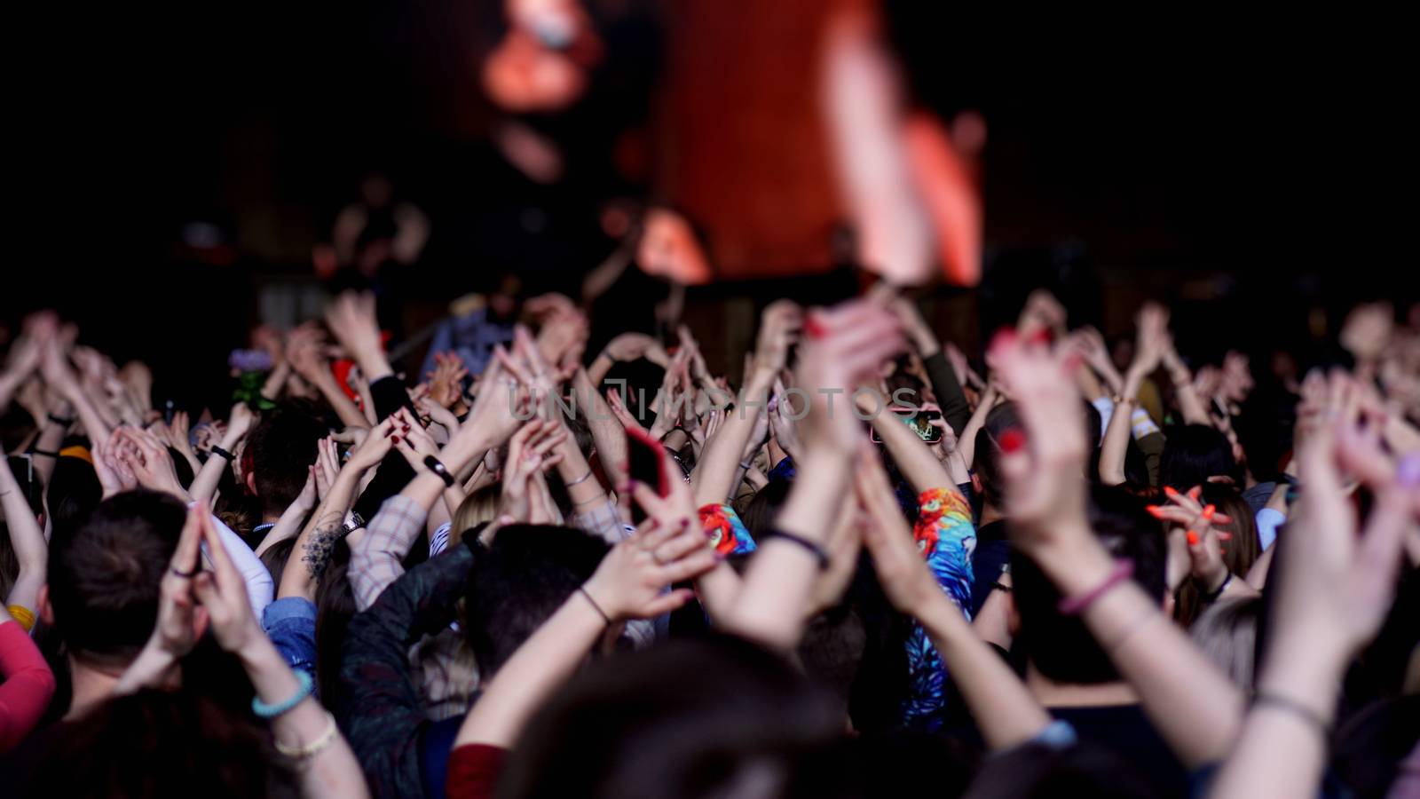 Crowd at concert - Cheering crowd in bright colorful stage lights. Audience At Outdoor Music Festival