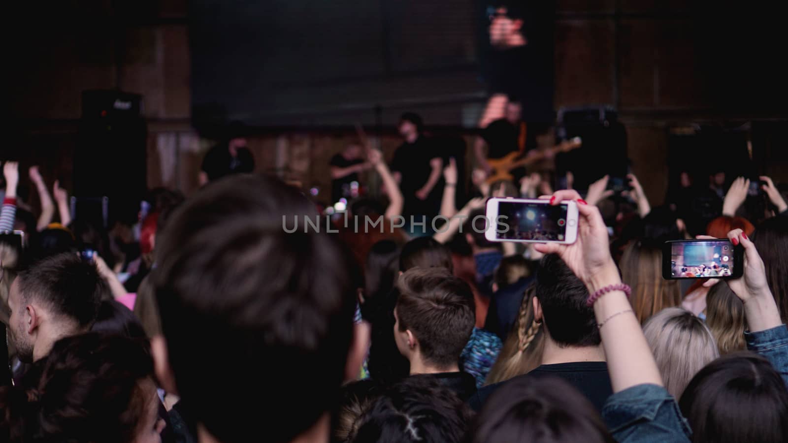 People taking photographs with touch smart phone during a music entertainment public concert. Audience At Outdoor Music Festival