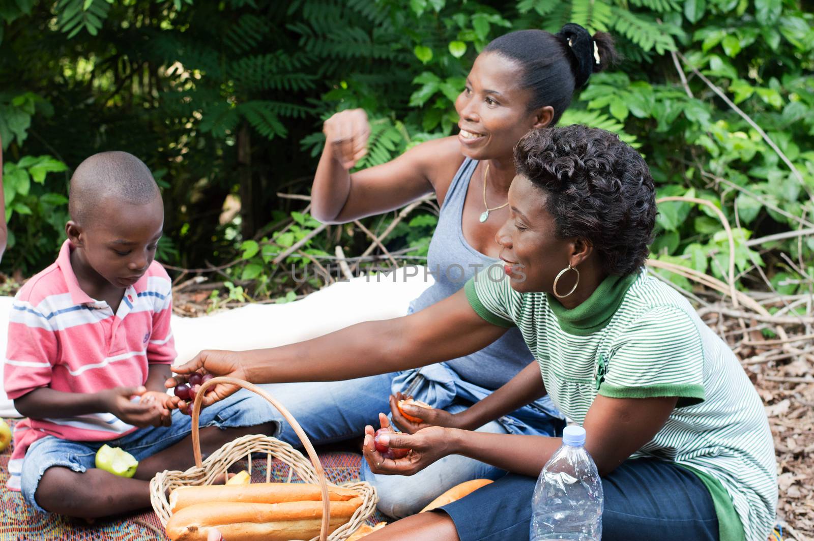 sitting on a mat, this small family camp in the countryside. And this young woman gives grapes to her son