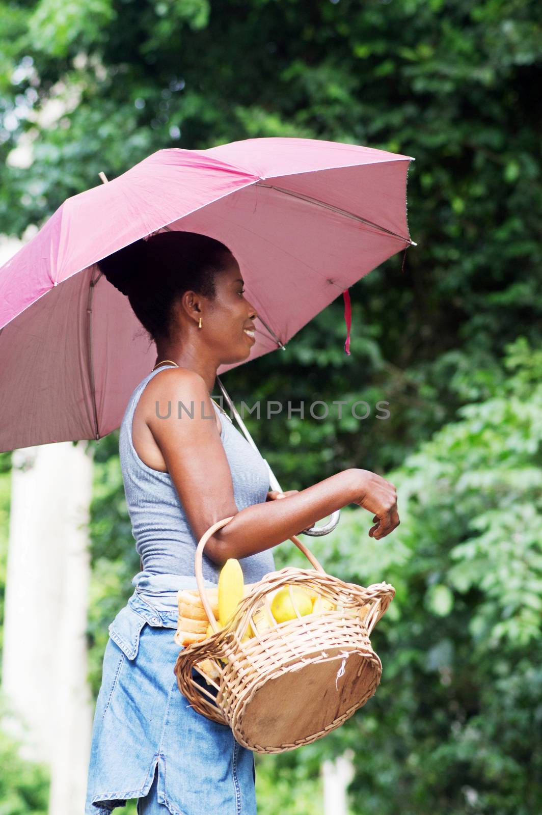 Young woman carrying a basket full of provisions.