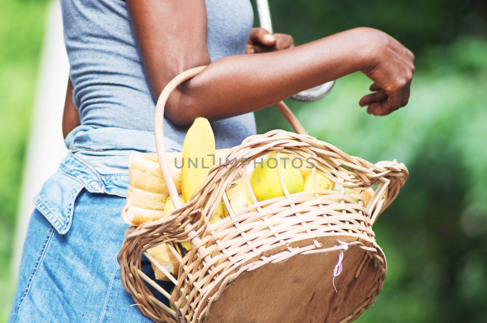 Young woman carrying a basket full of provisions.