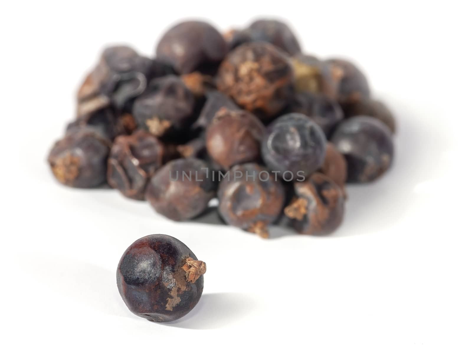 Dried juniper berries isolated on white. Soft focus view. Close up.