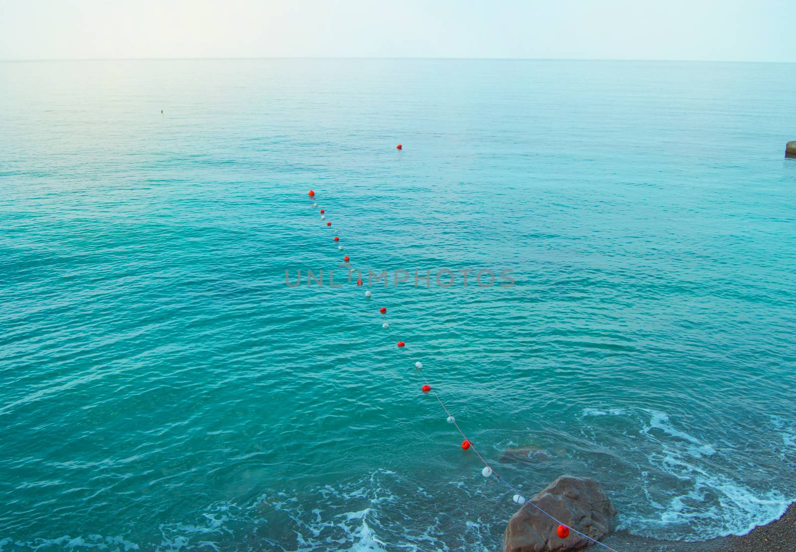 Separation buoys in the sea for safe swimming on the beach.