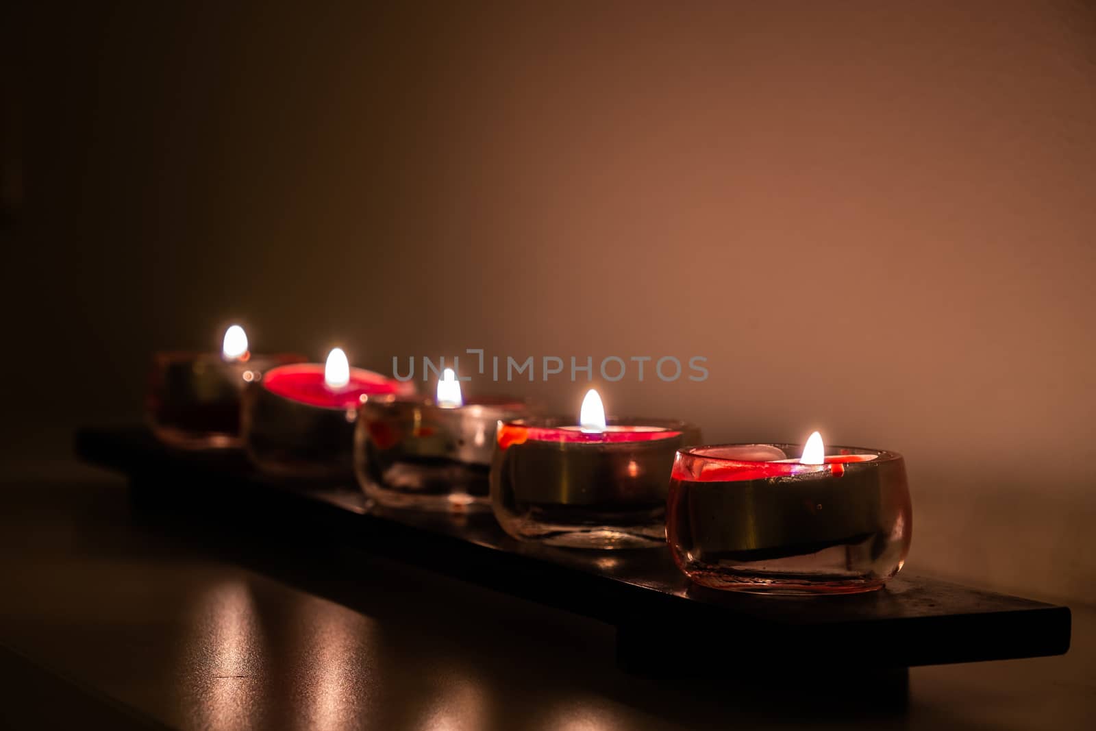 A roll of small red candles as light source.