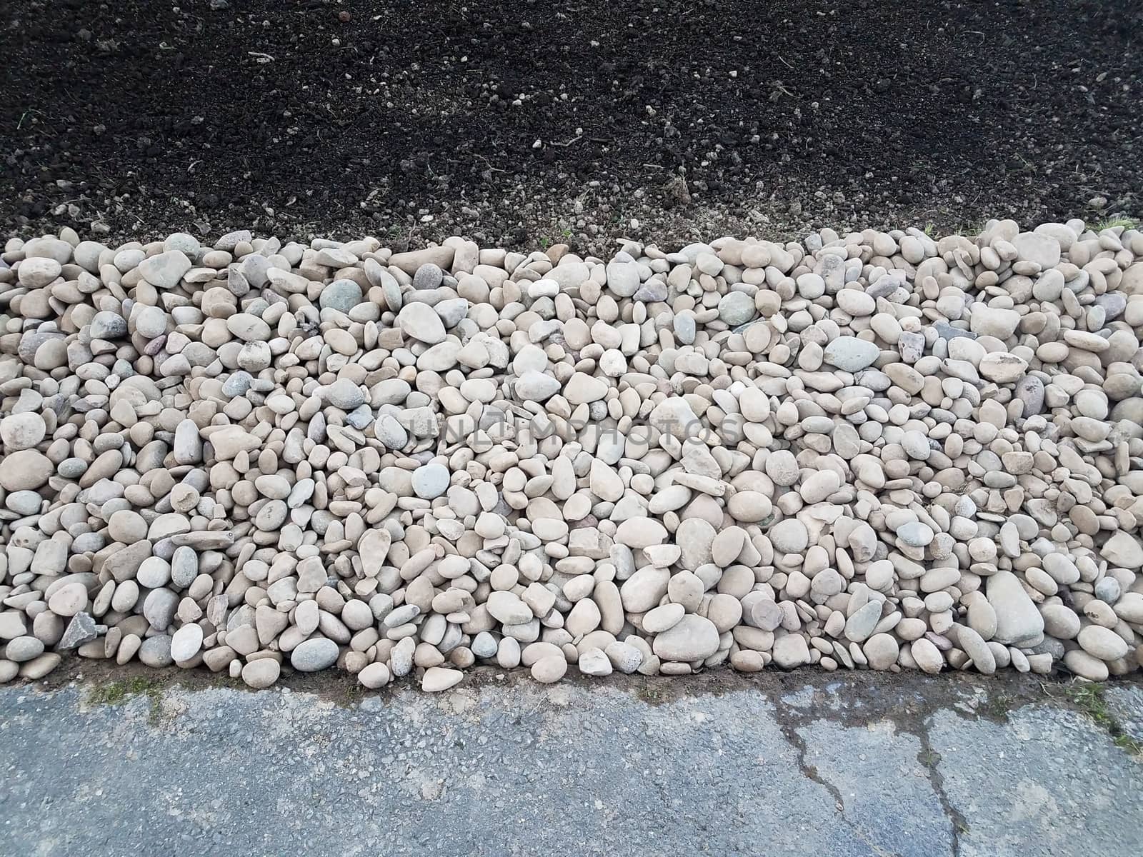 white and grey stones or rocks with brown dirt or soil and asphalt