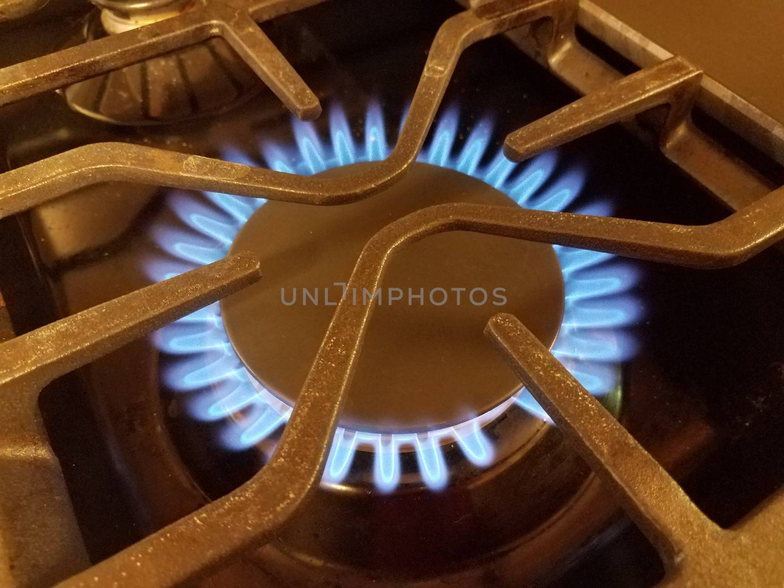 hot blue flame on natural gas stove top with metal grate