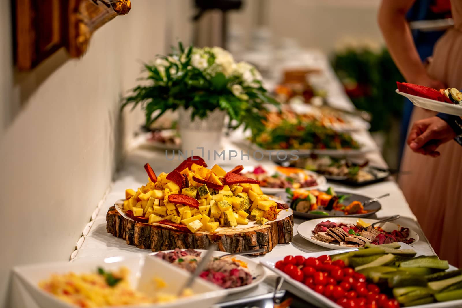 Cheese, vegetables, meat and other snacks on the festive table in the restaurant. Cheese snacks, vegetables and other appetizers on holiday table. Catering wedding table.