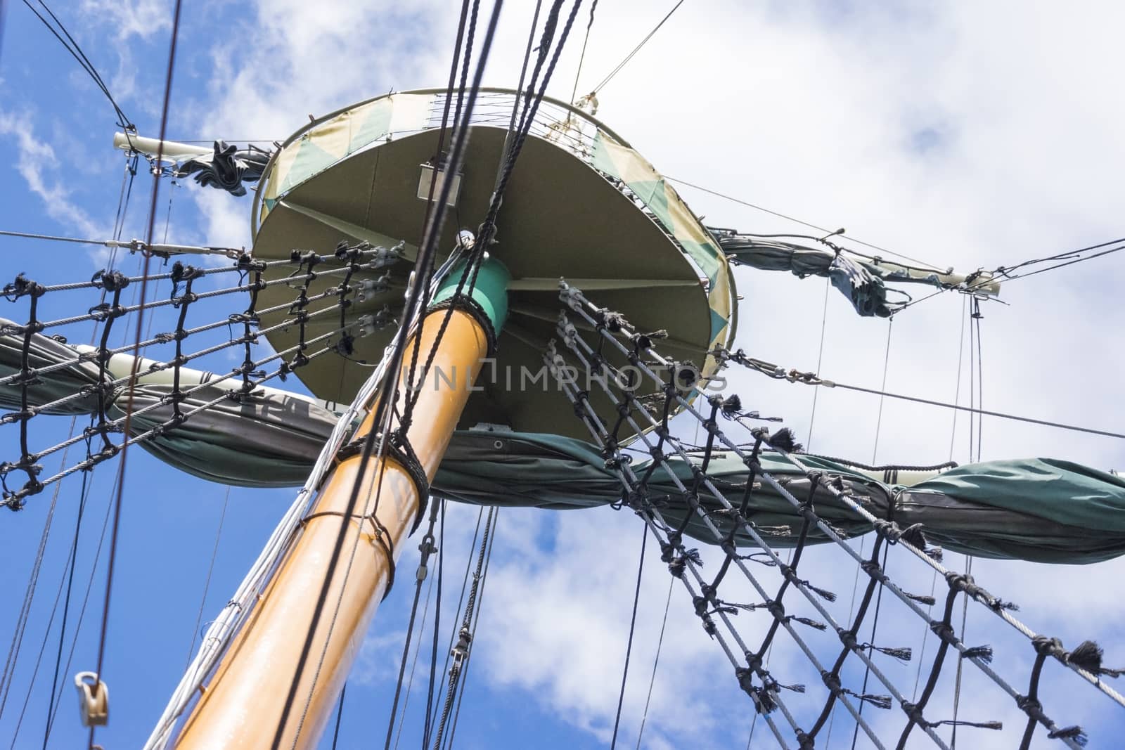 mast of a sea ship with rigging and a sailing port