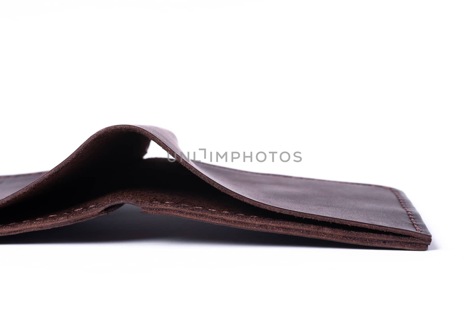 A part of brown handmade leather man wallet isolated on white background. Wallet is open. Stock photo of luxury businessman accessories.