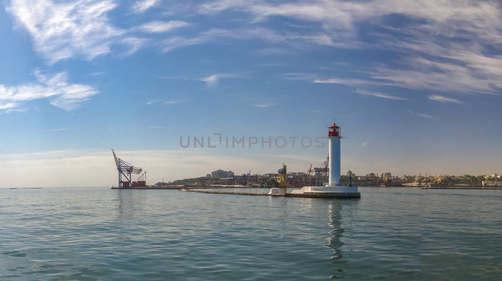 Lighthouse at the entrance to the harbor of the Odessa port, the sea gates of Ukraine in a sunny summer day