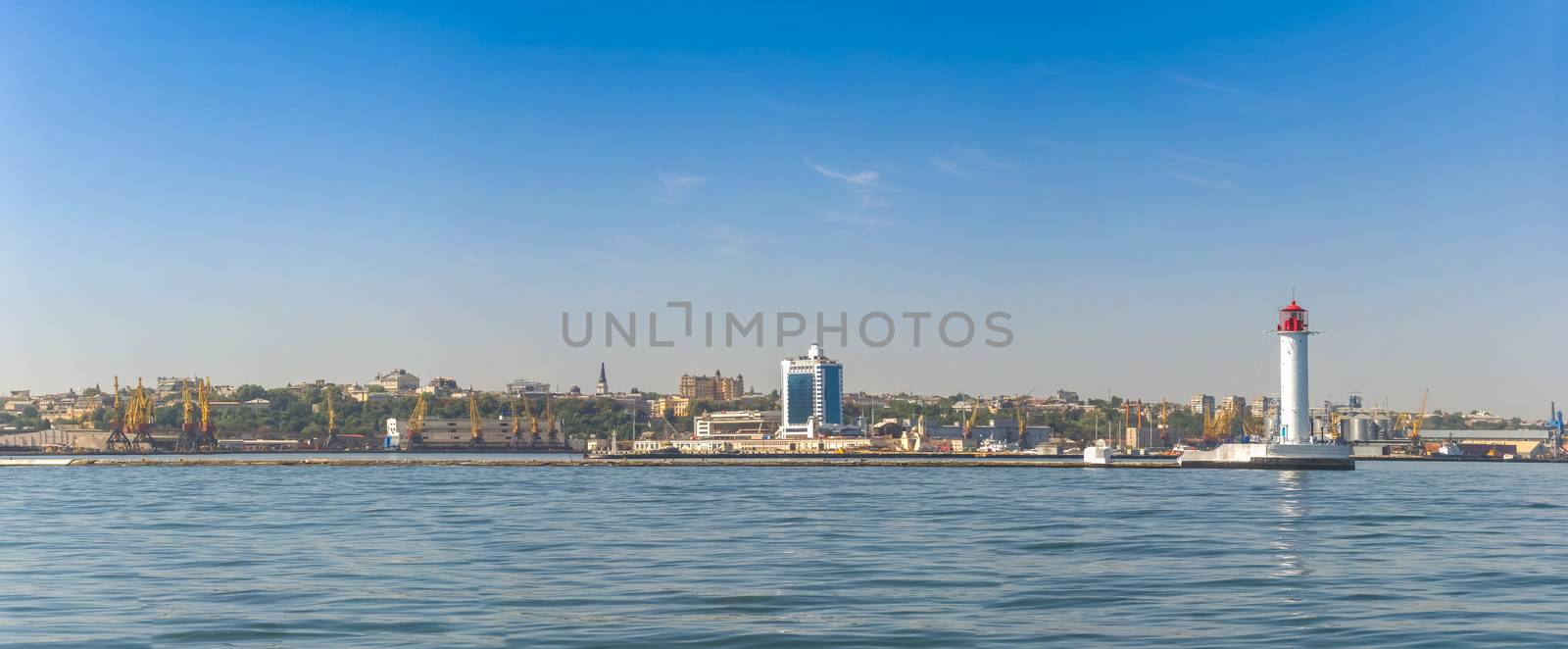 Lighthouse at the entrance to the harbor of the Odessa port, the sea gates of Ukraine in a sunny summer day