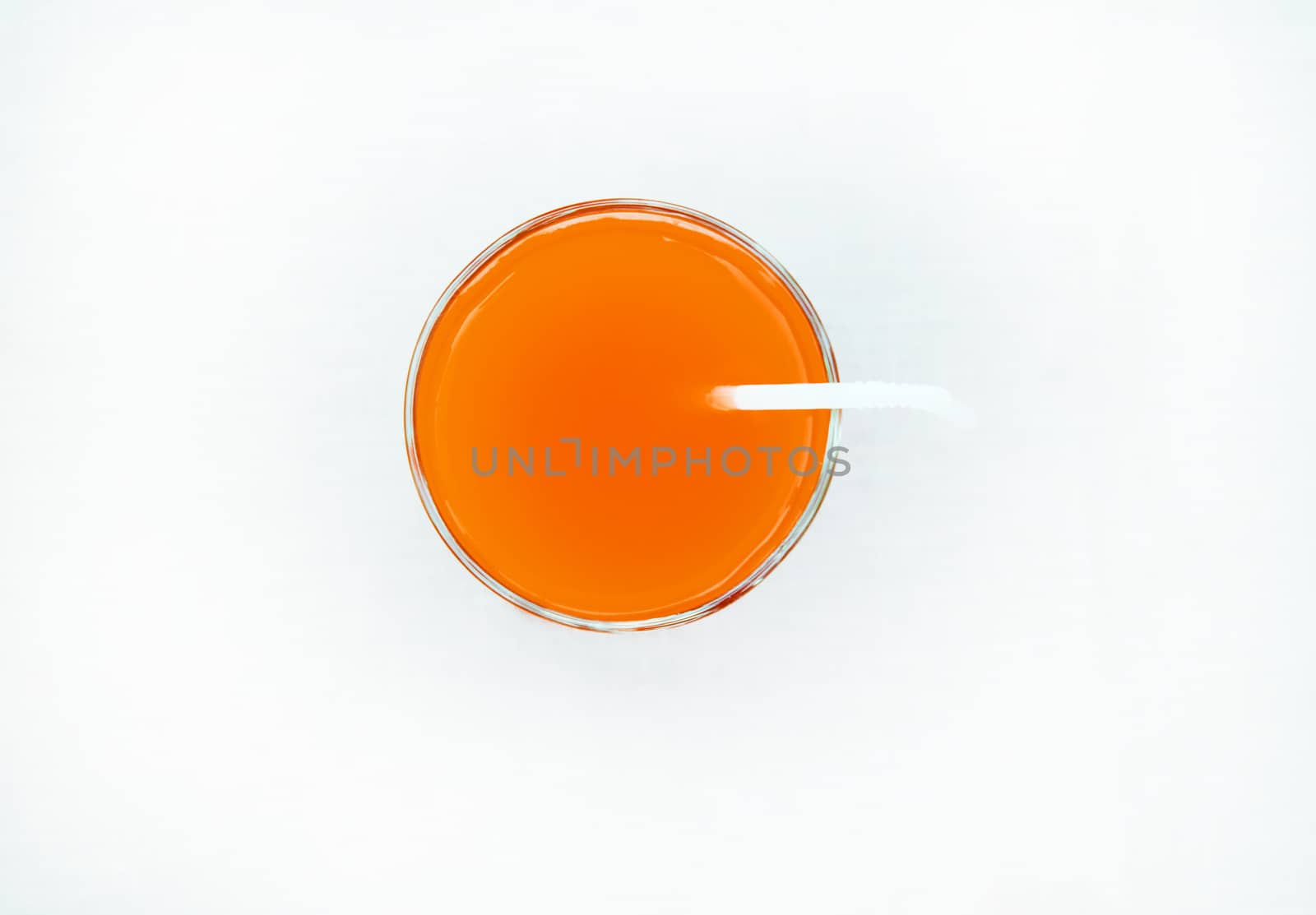 Summer drink - freshly squeezed grapefruit juice in a glass with a straw tube, top view, isolated on a white background with clipping, minimalism by claire_lucia