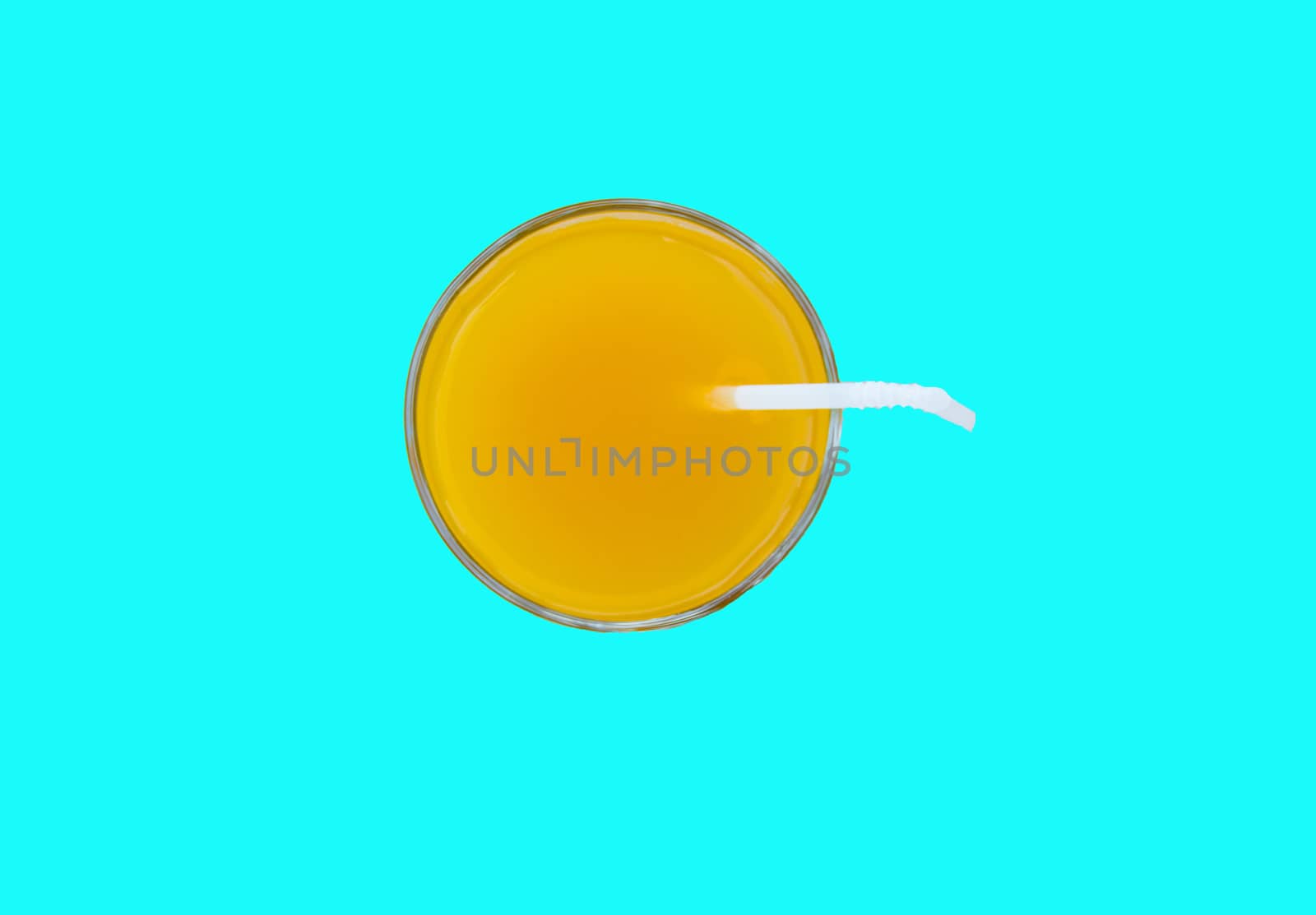Summer drink - freshly squeezed orange juice in a glass with a straw tube, top view, isolated on a blue background with clipping, minimalism style.