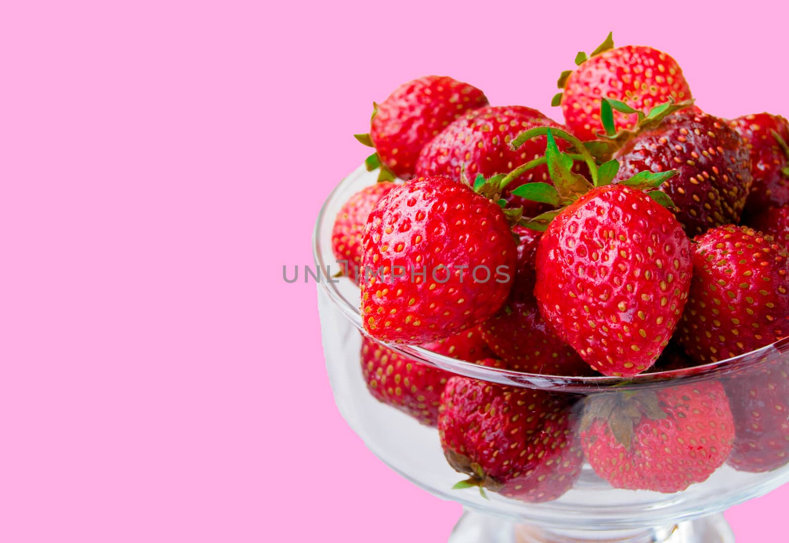 Glass bowl with fresh ripe strawberries, space for text, copy space isolated on pink background, layout, clipping.