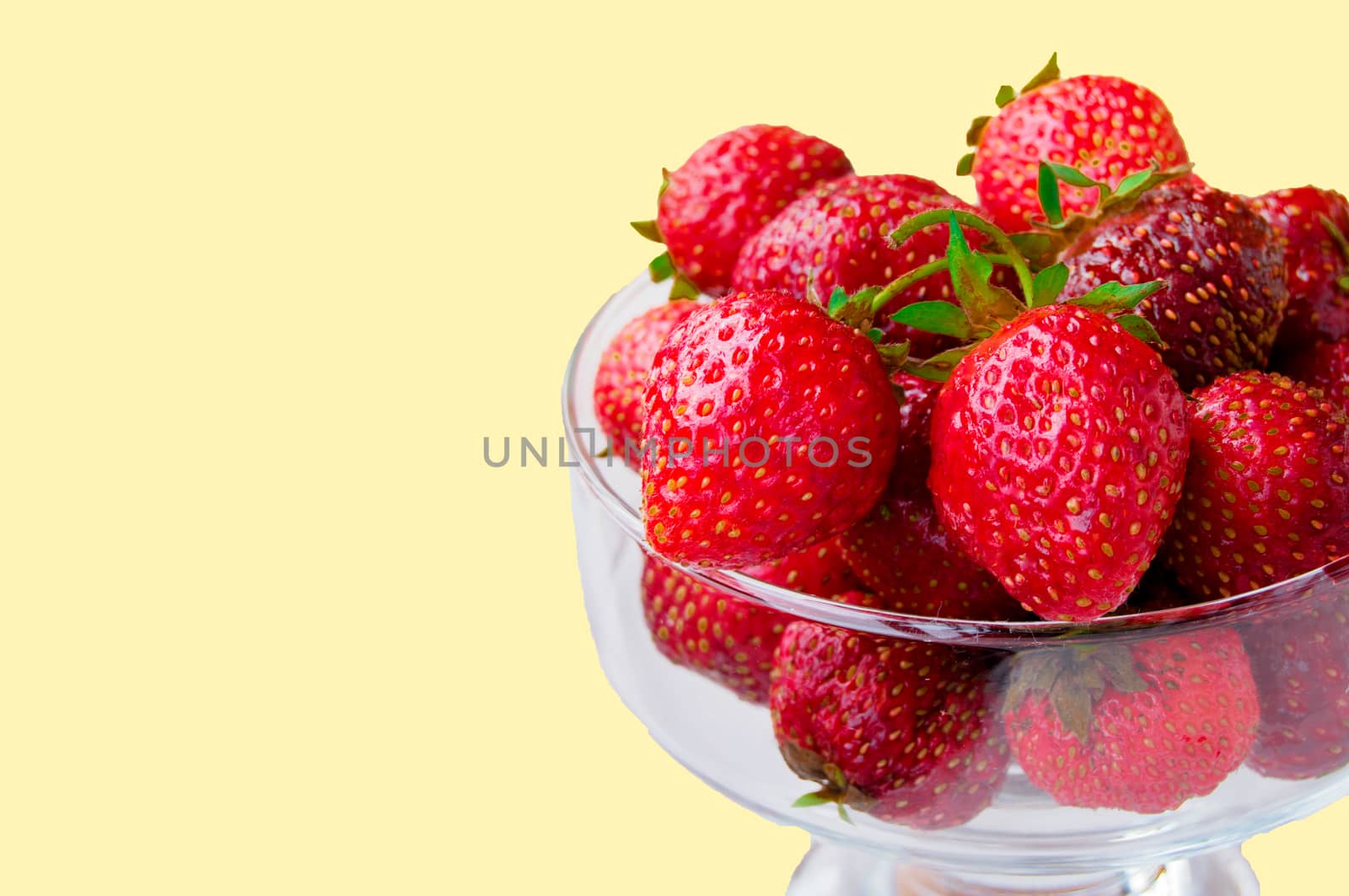 Glass bowl with fresh ripe strawberries, space for text, copy space isolated on yellow background, layout, clipping by claire_lucia