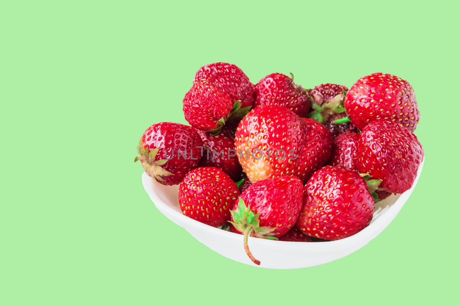 Glass bowl with fresh ripe strawberries, space for text, copy space isolated on green background, layout, clipping.