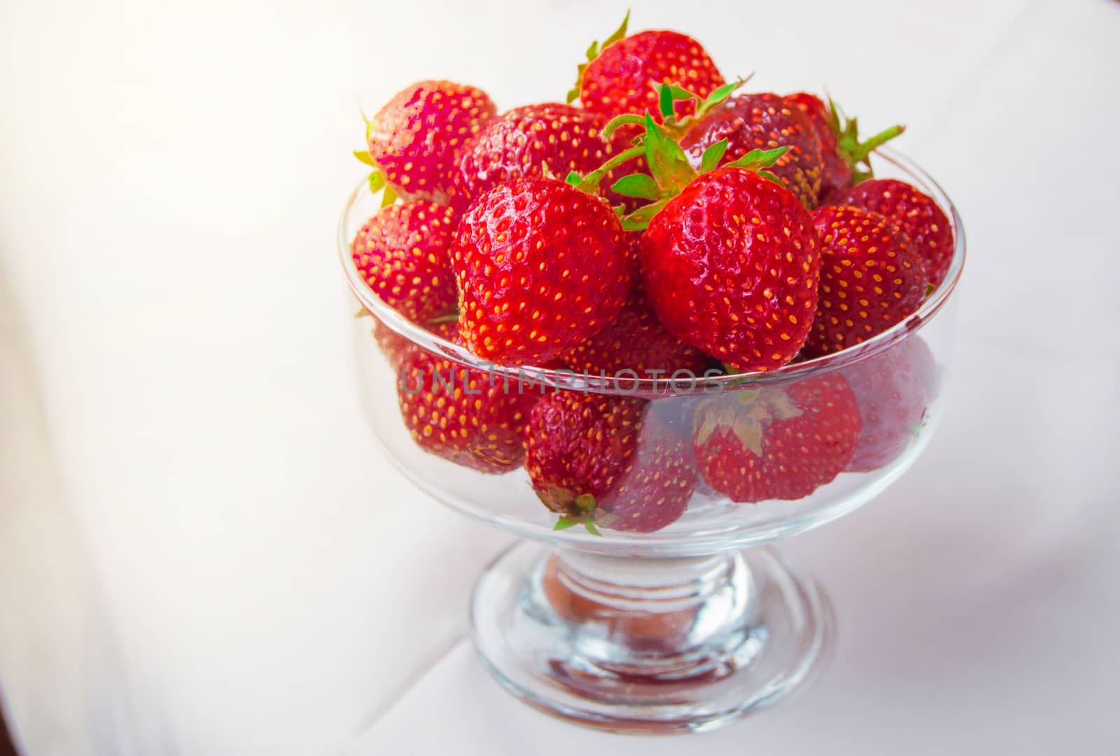 Glass bowl of fresh ripe strawberries on the tablecloth by claire_lucia